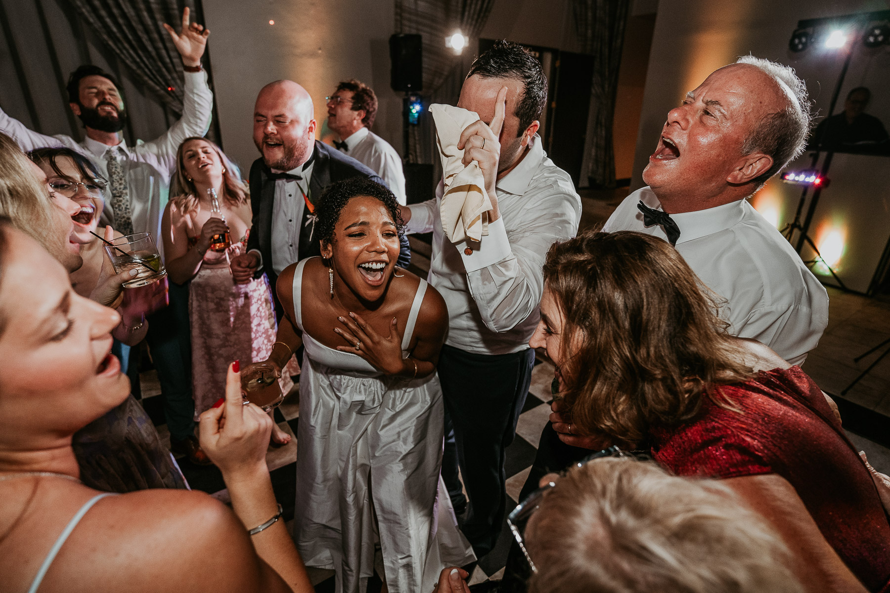 Dance floor shot of the couple surrounded by their guests.