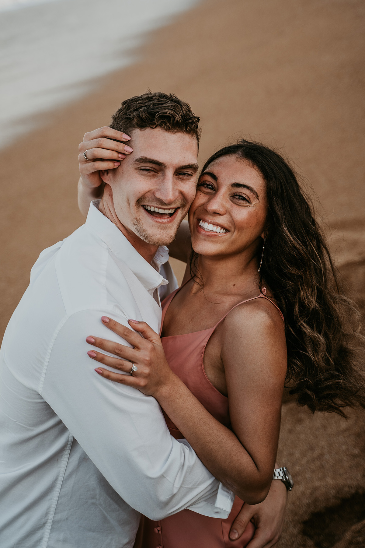 Stunning Puerto Rico beach proposal captured with family watching in the distance.