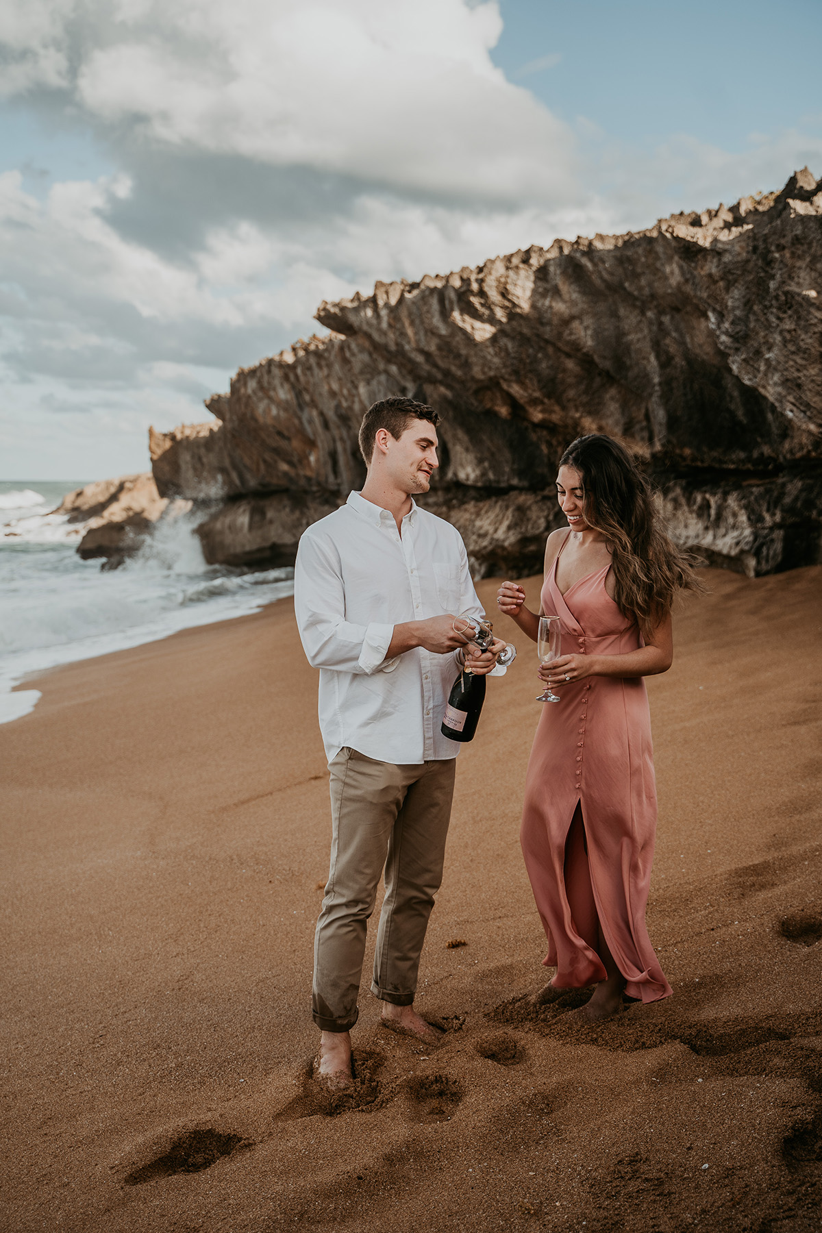 Couple opening champagne to celebrate proposal in Puerto Rico.