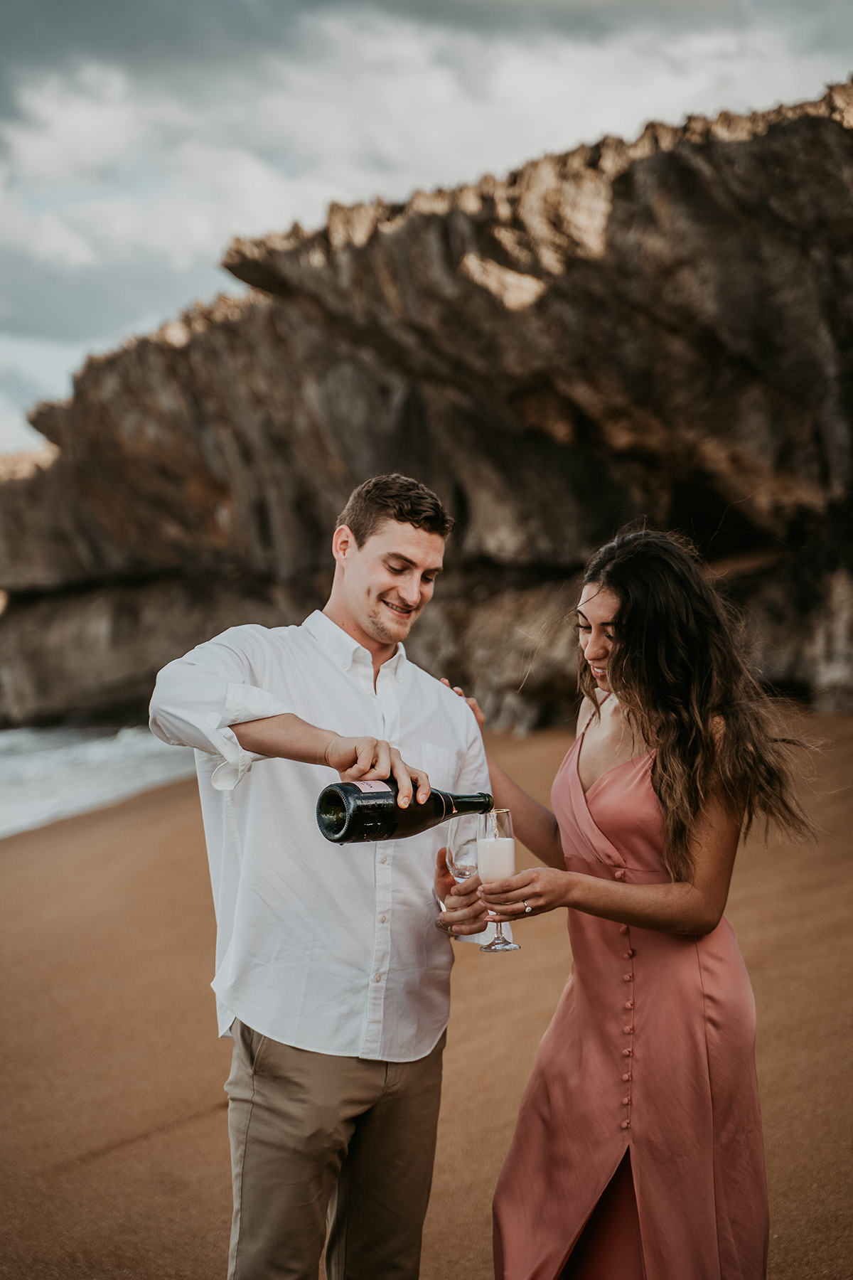 Couple opening champagne to celebrate proposal in Puerto Rico.