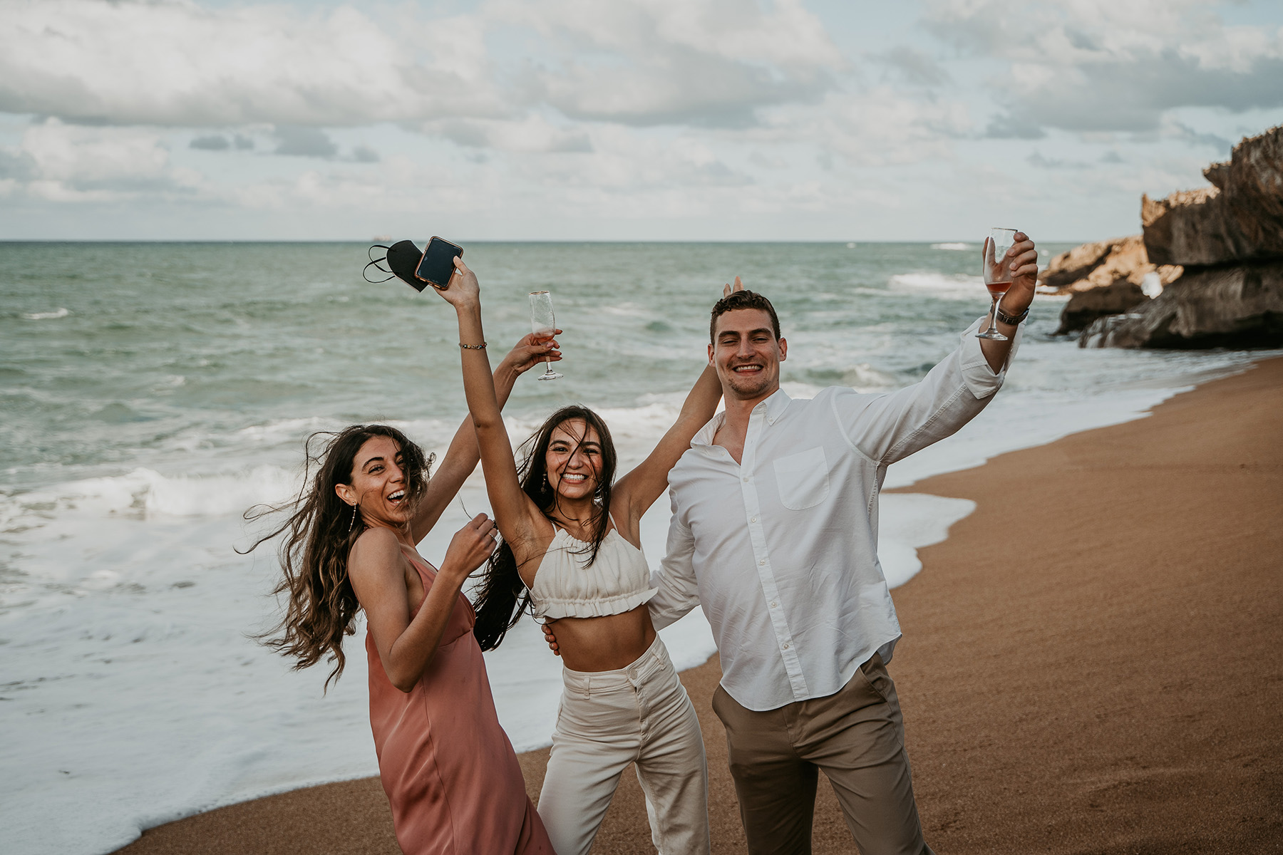 Stunning Puerto Rico beach proposal captured with family watching in the distance.