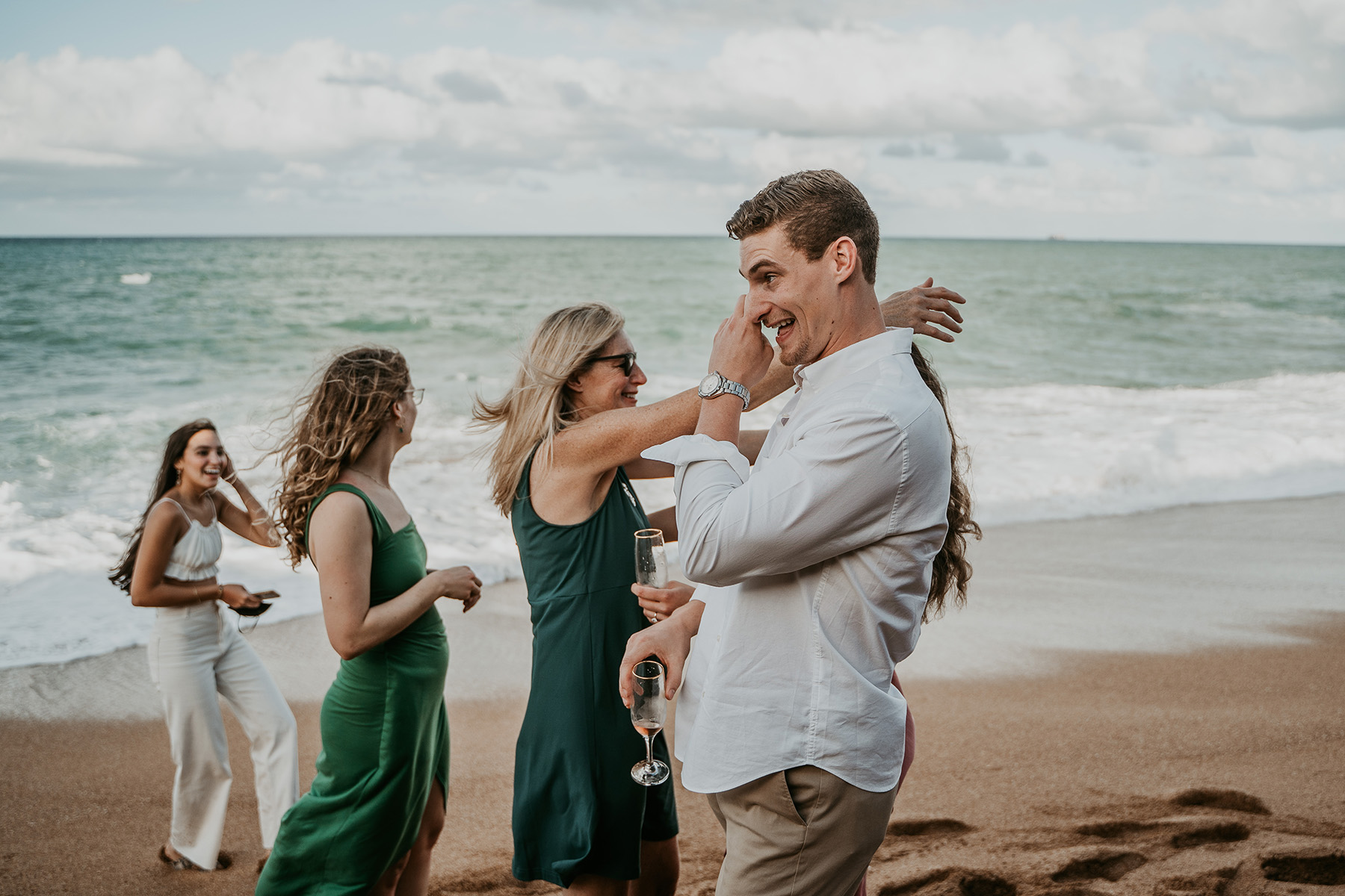 Stunning Puerto Rico beach proposal captured with family watching in the distance.