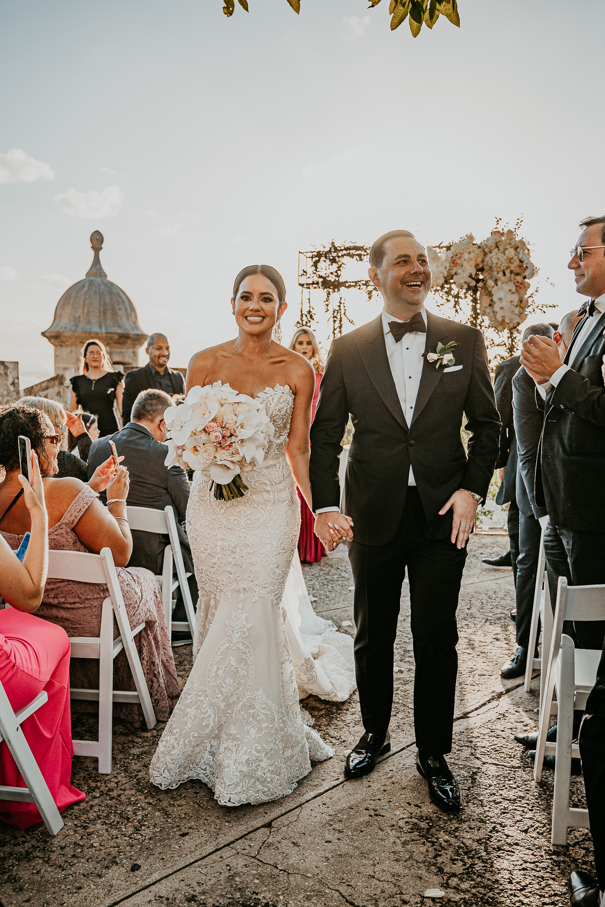 Outdoor wedding ceremony at La Rogativa, overlooking San Juan Bay with historic bronze statue in Old San Juan.