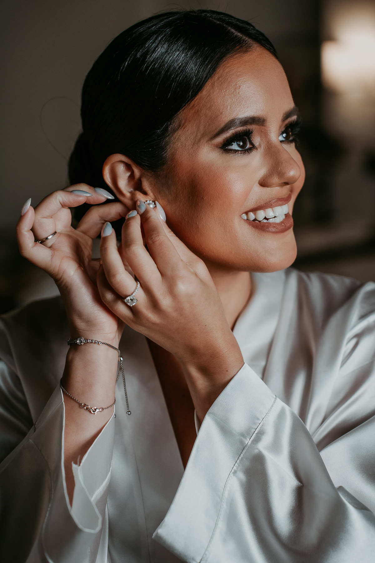 Candid photo of bride during hair and makeup.