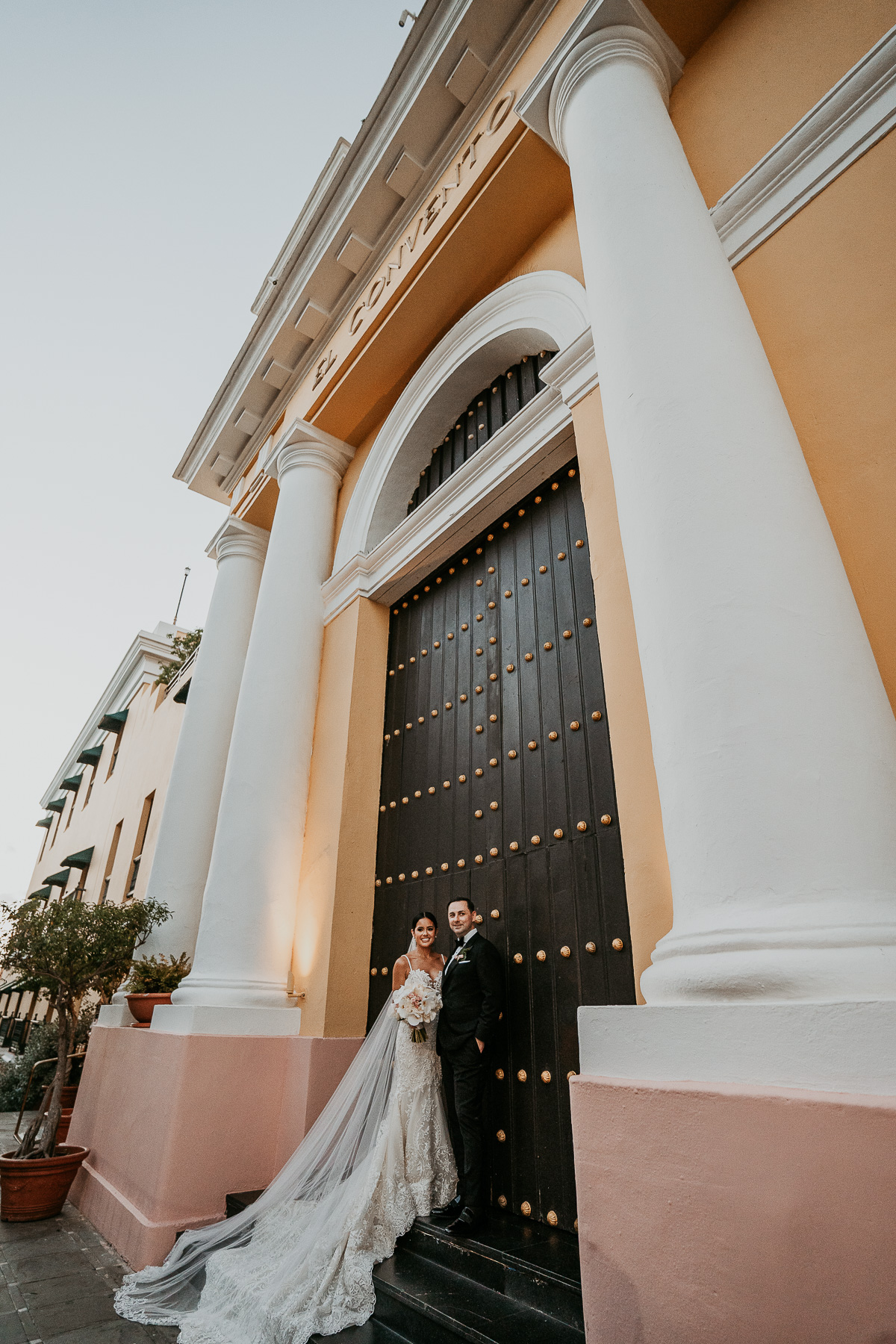 Bride and groom in front of Hotel El Convento doors.