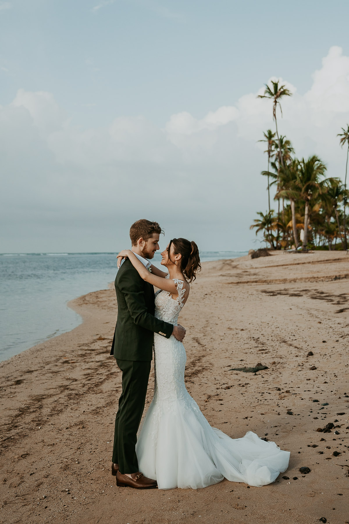 Newlyweds posing for photos outdoors at the Hyatt Regency Grand Reserve after the rain cleared, capturing the ocean and clear sky.