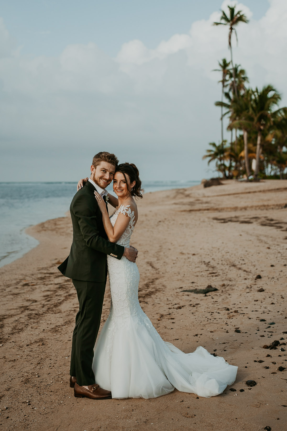 Newlyweds posing for photos outdoors at the Hyatt Regency Grand Reserve after the rain cleared, capturing the ocean and clear sky.