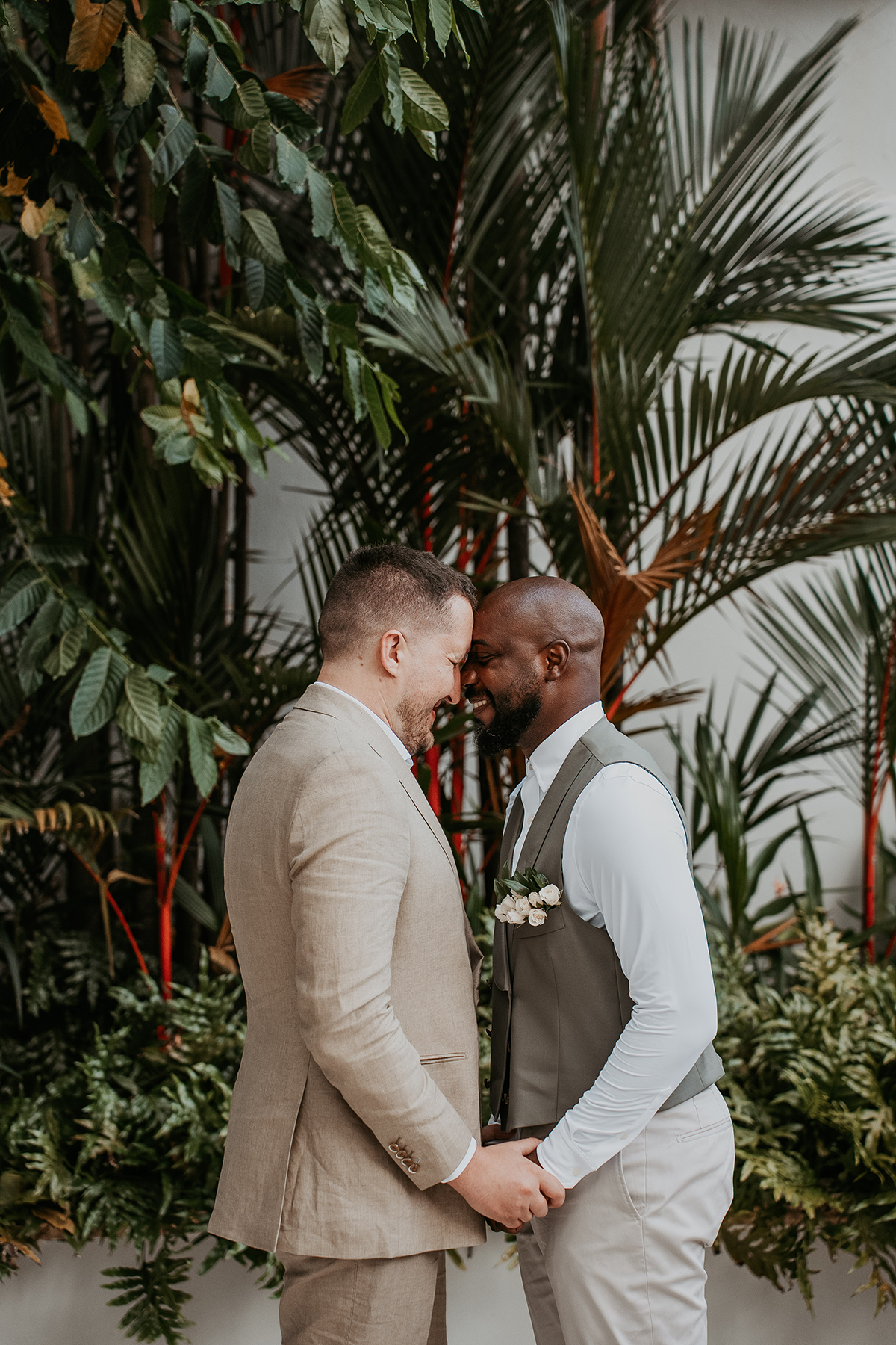 The grooms smile and embrace during their intimate first look.
