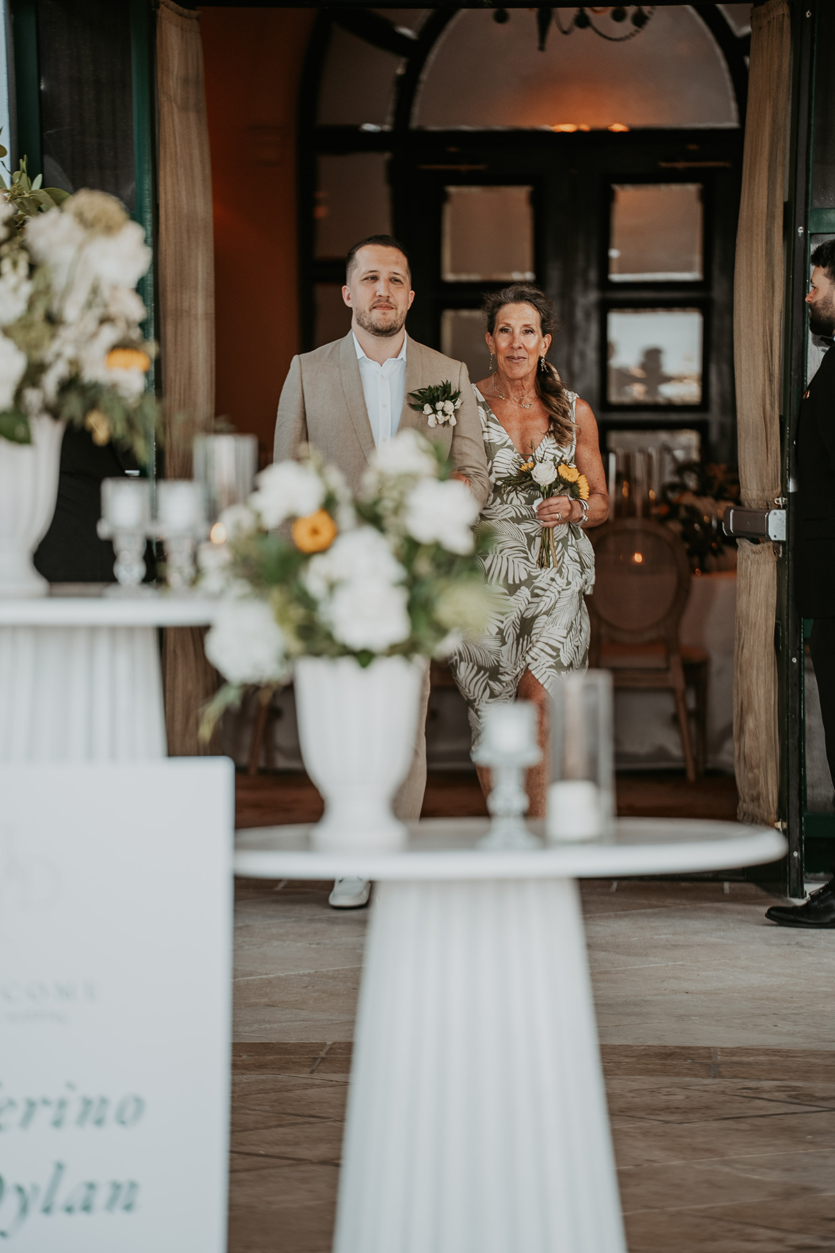 One groom walks down the aisle with his mother during the wedding ceremony.