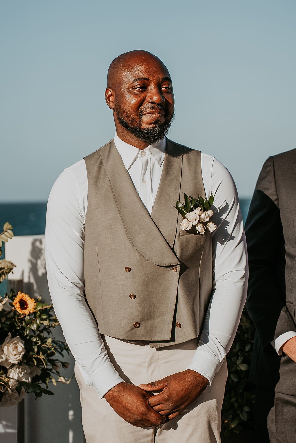: One groom smiles emotionally as he sees his partner approaching the ceremony.