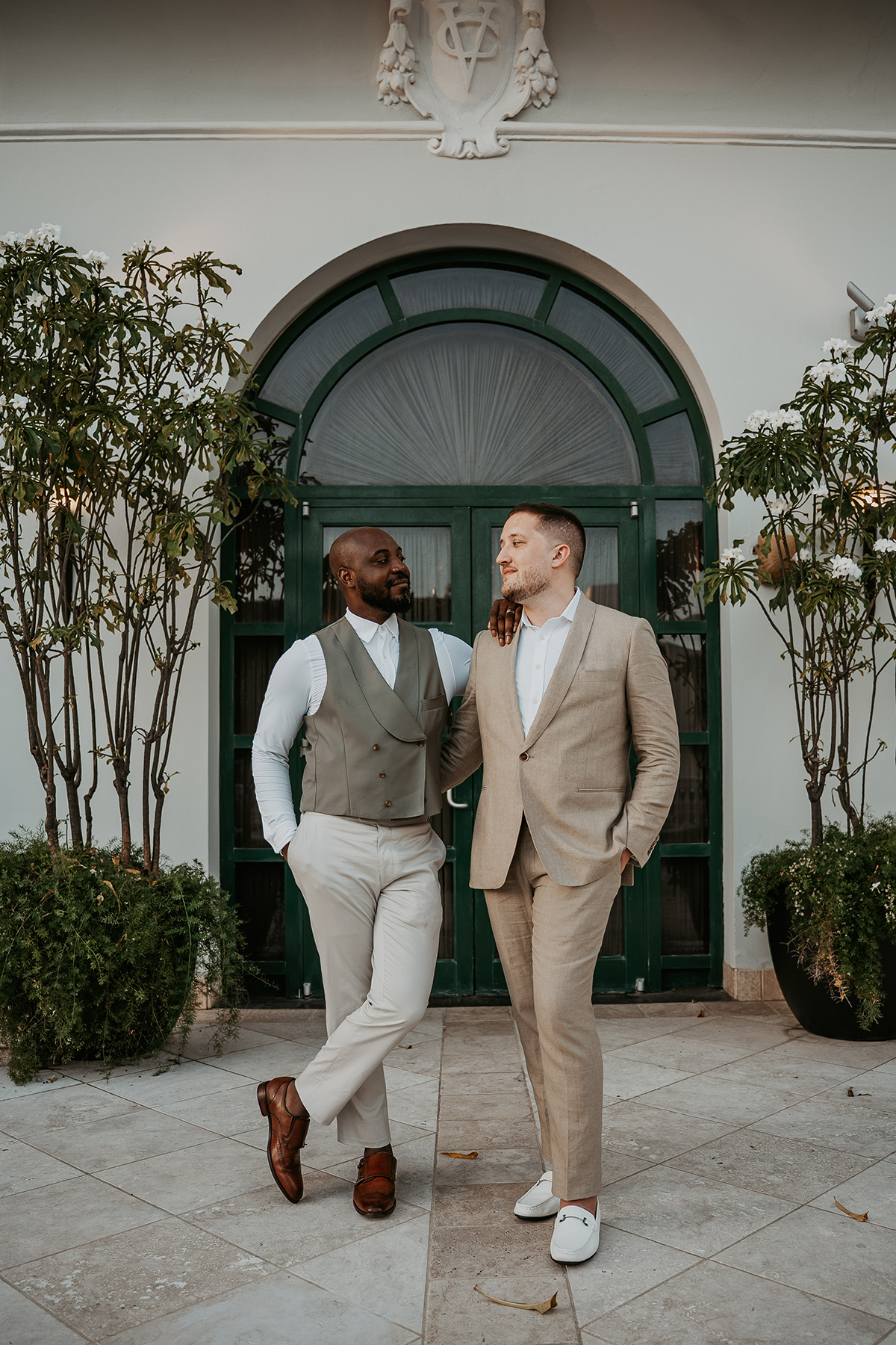 The newlyweds pose together outdoors at their wedding venue.
