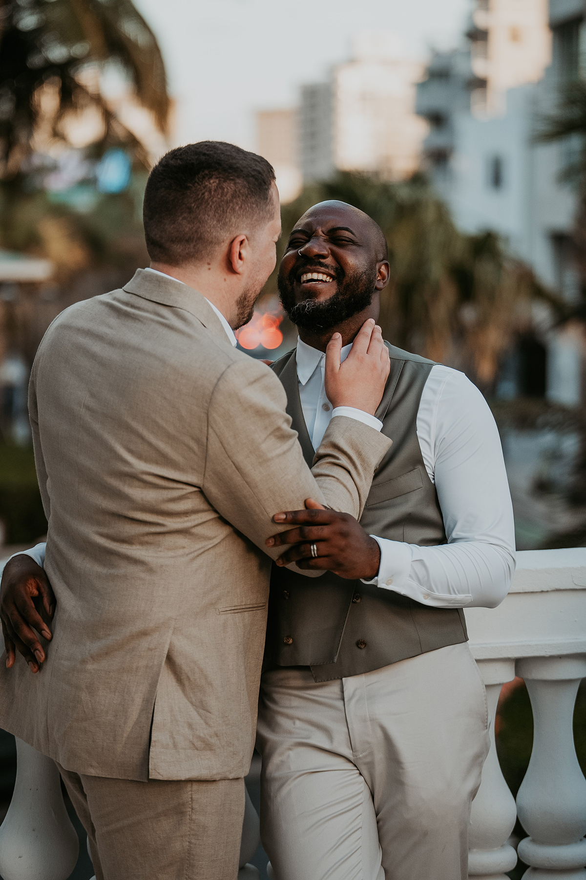 The grooms share a playful, affectionate moment during their wedding portraits.