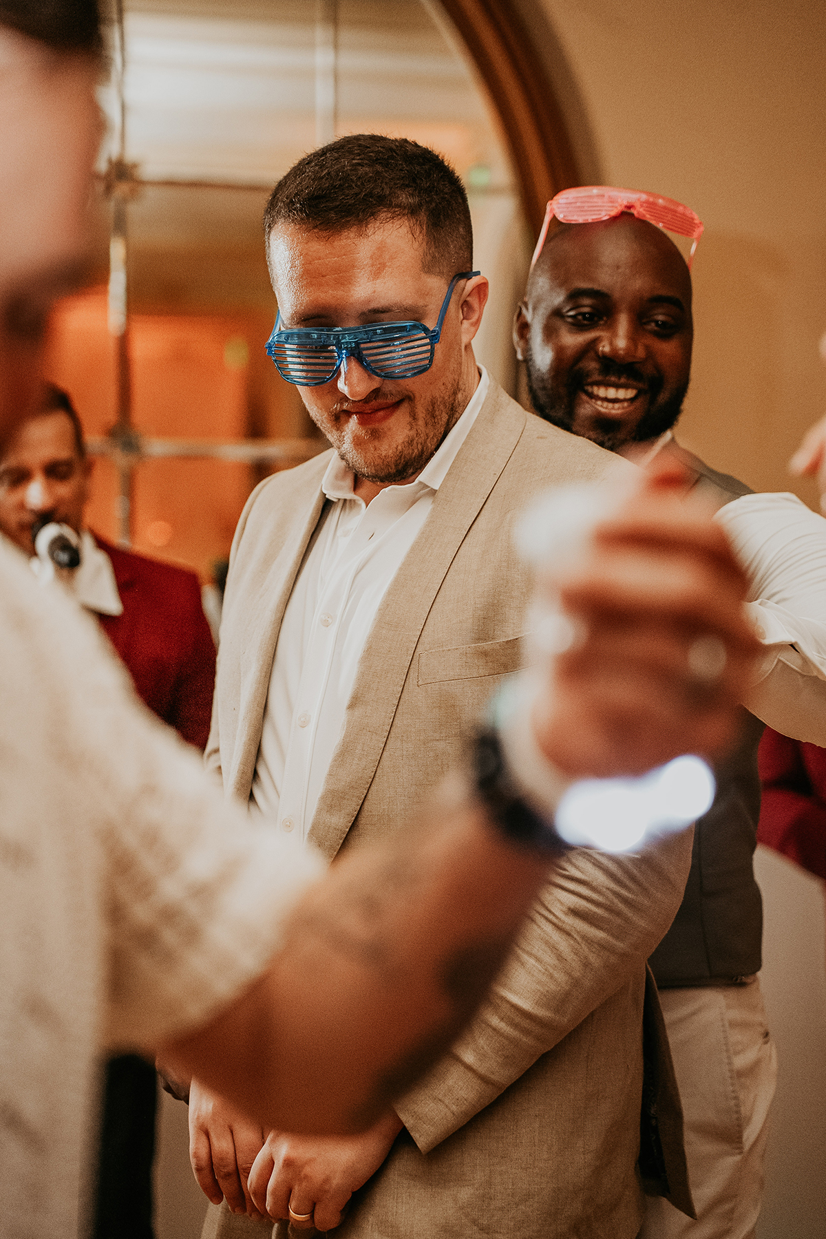 The grooms smile and interact with guests during their wedding celebration.
