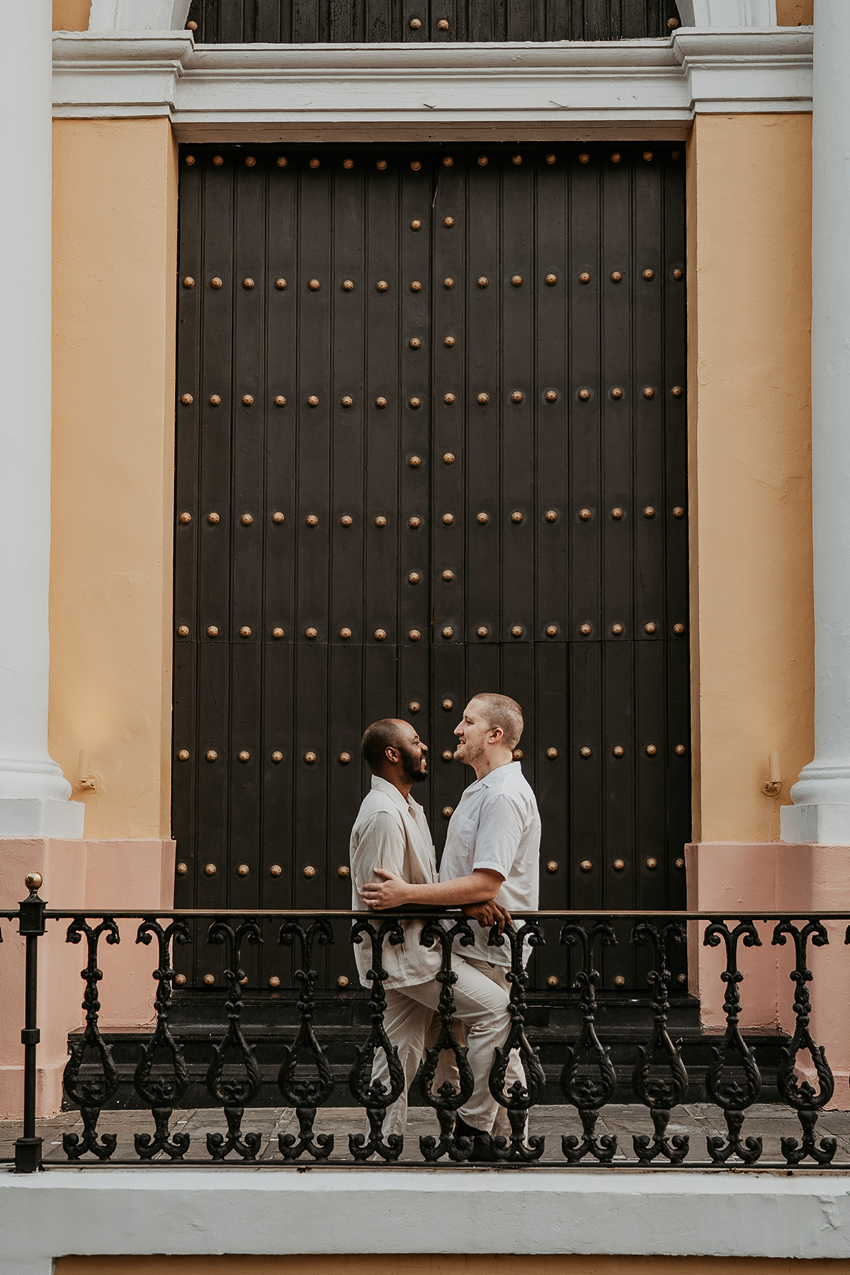 Two grooms walk hand in hand along the blue cobblestone streets of Old San Juan.