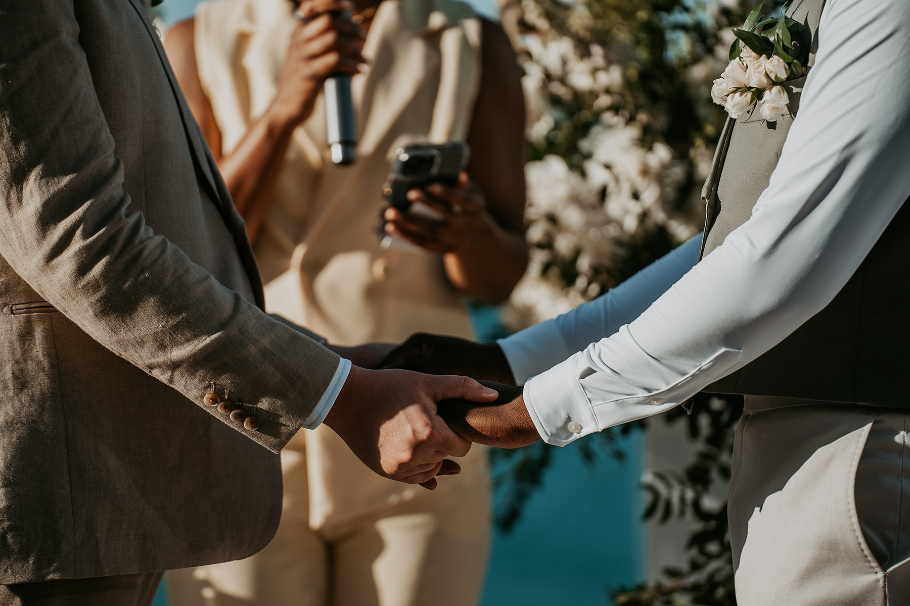 Close up of hand holding moment between the grooms during their wedding ceremony.