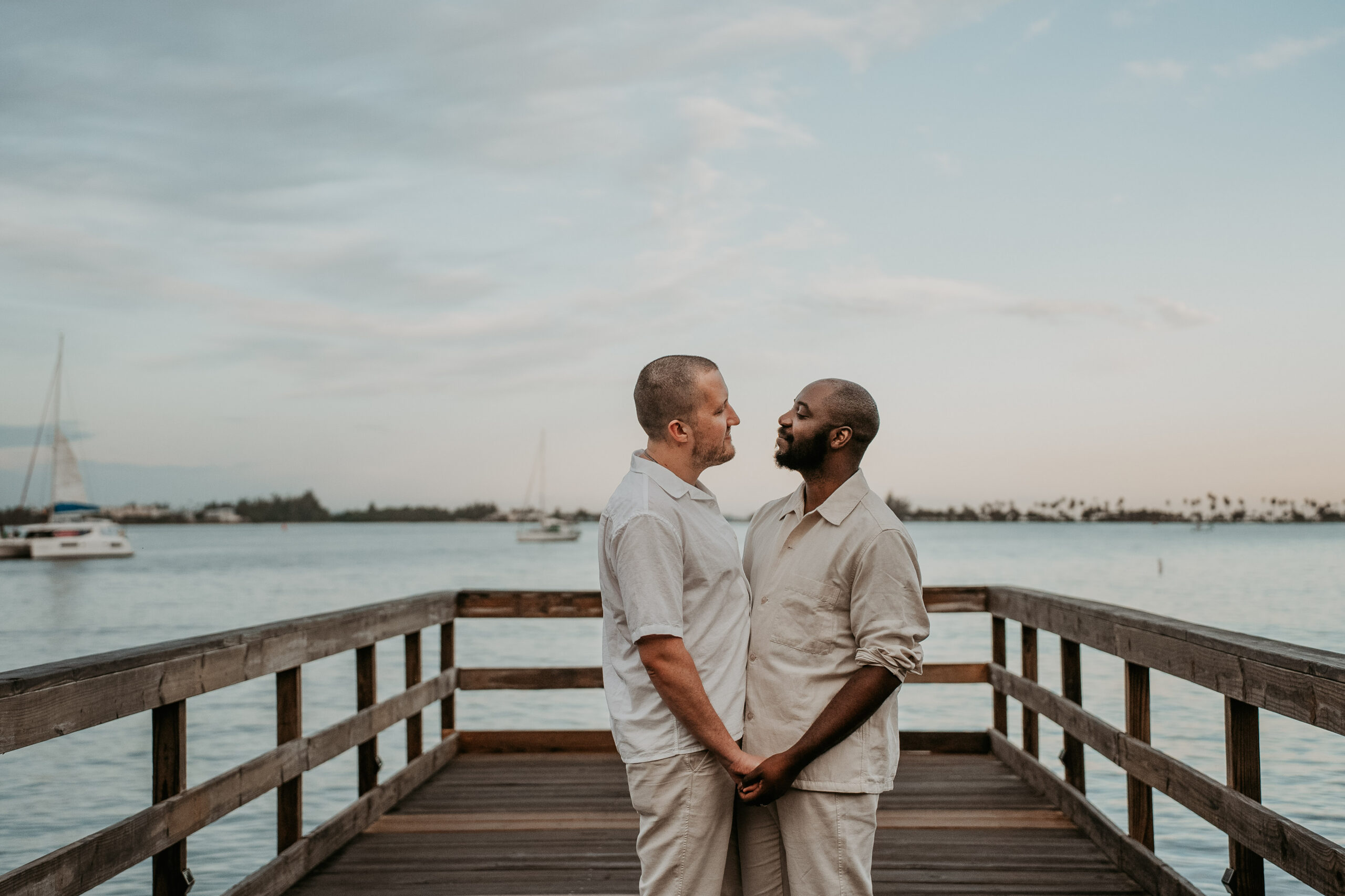An interracial gay couple embraces during a relaxed beachfront couple session in Puerto Rico.