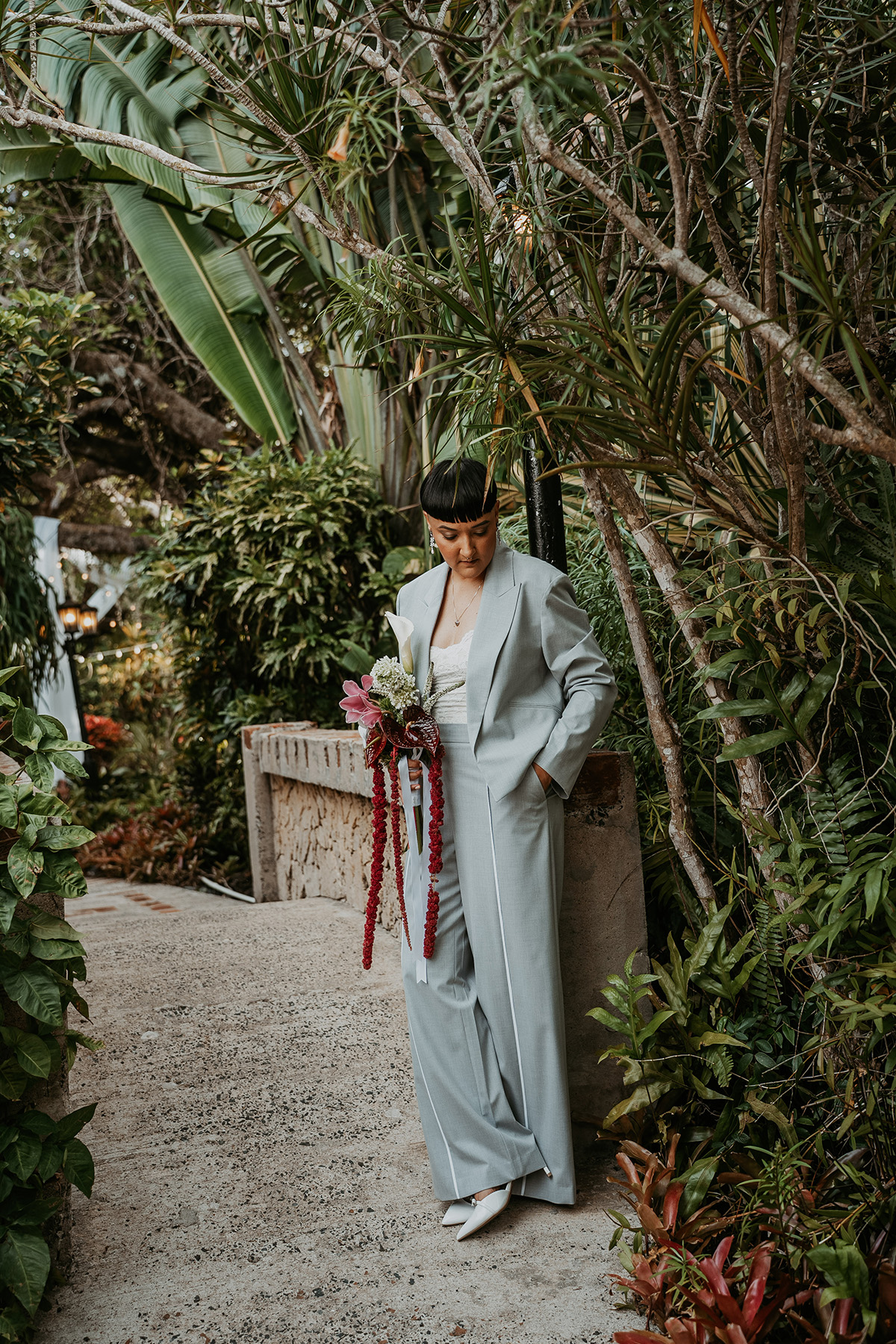 Wide shot of masc bride posing while getting ready for her Jardines del Castillo micro wedding in Puerto Rico