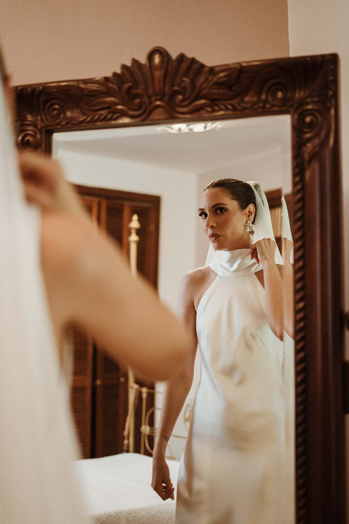 Bride looking in the mirror during wedding preparations at Jardines del Castillo