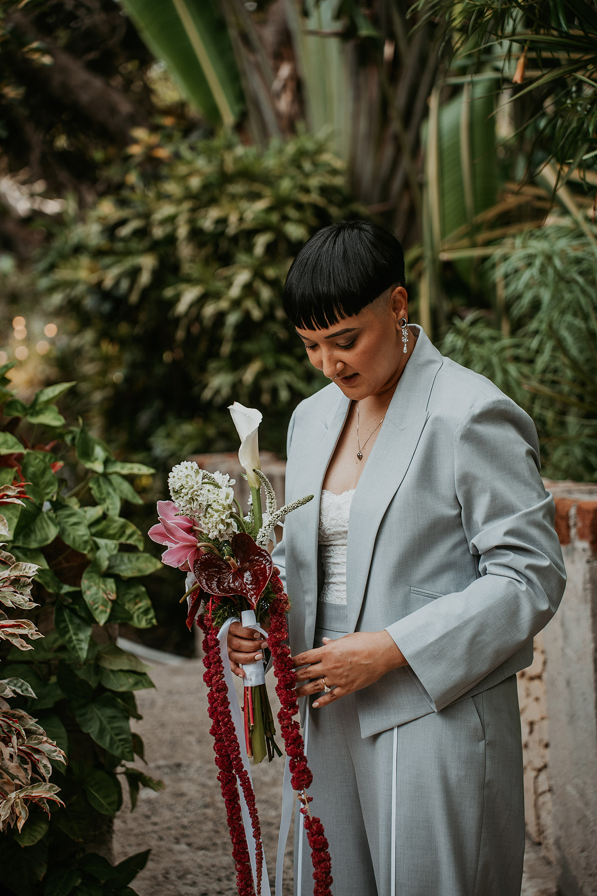 Masc bride posing while getting ready for her Jardines del Castillo micro wedding in Puerto Rico