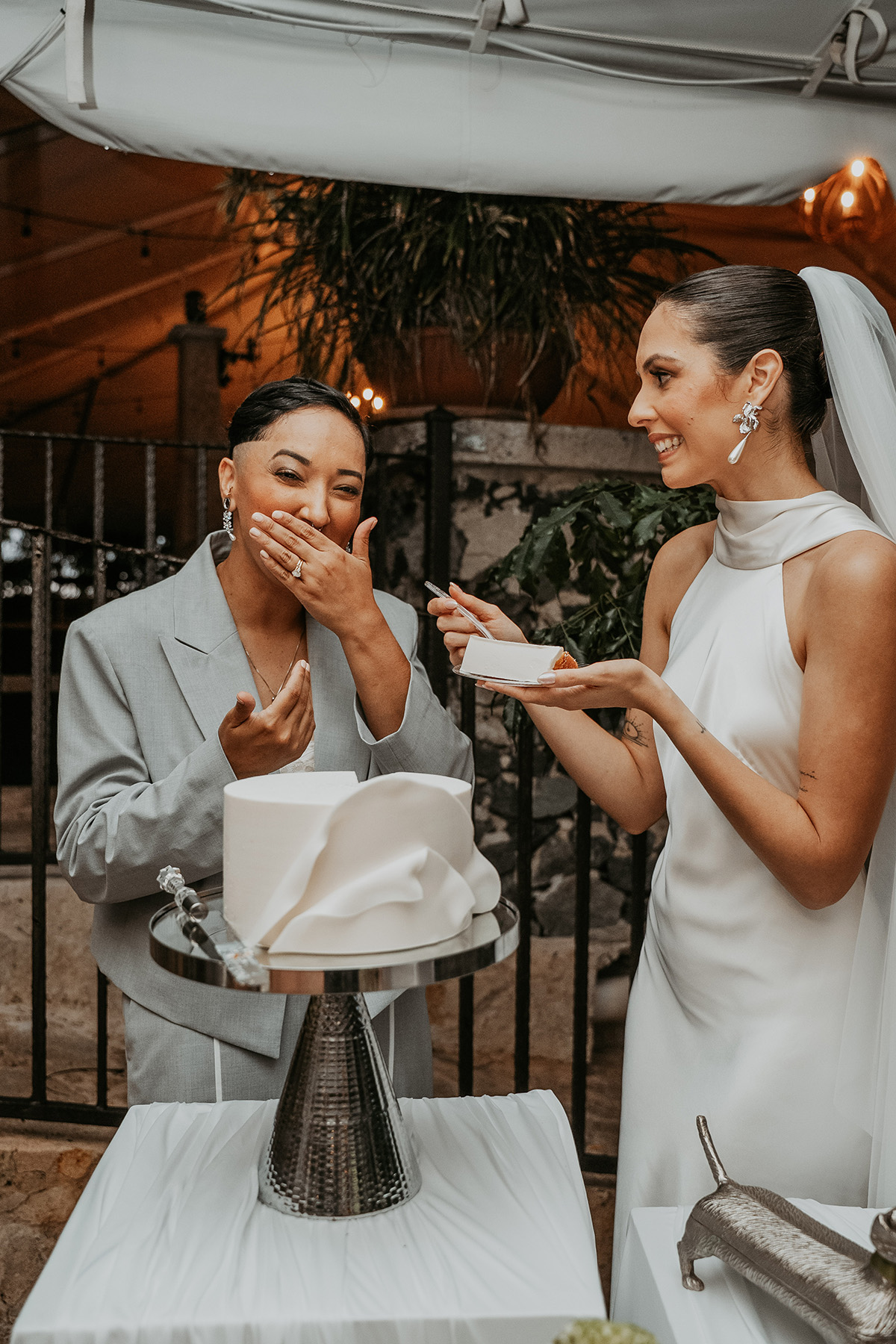 Two brides cutting their wedding cake together