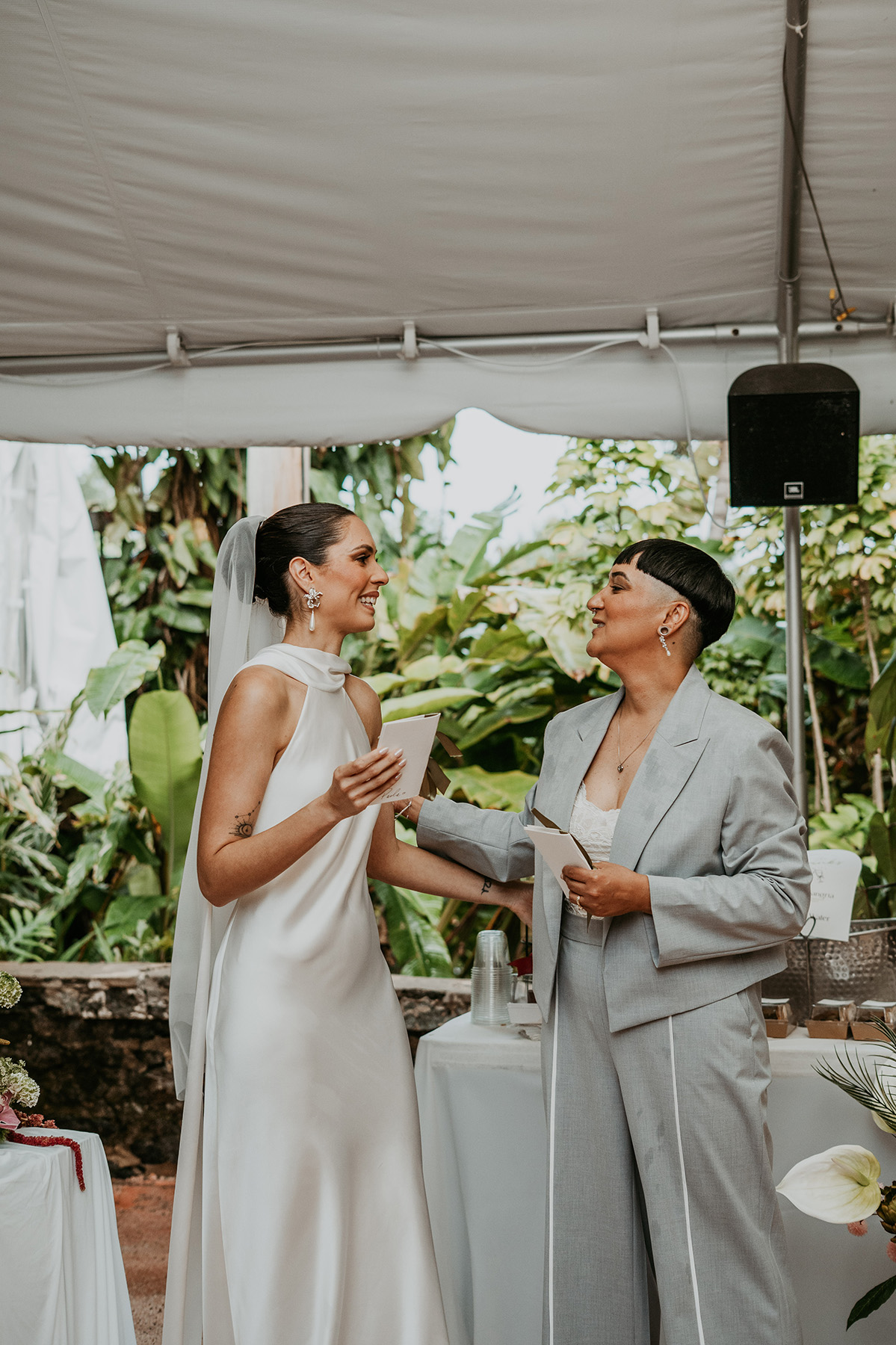 Newlywed couple surrounded by laughing wedding guests