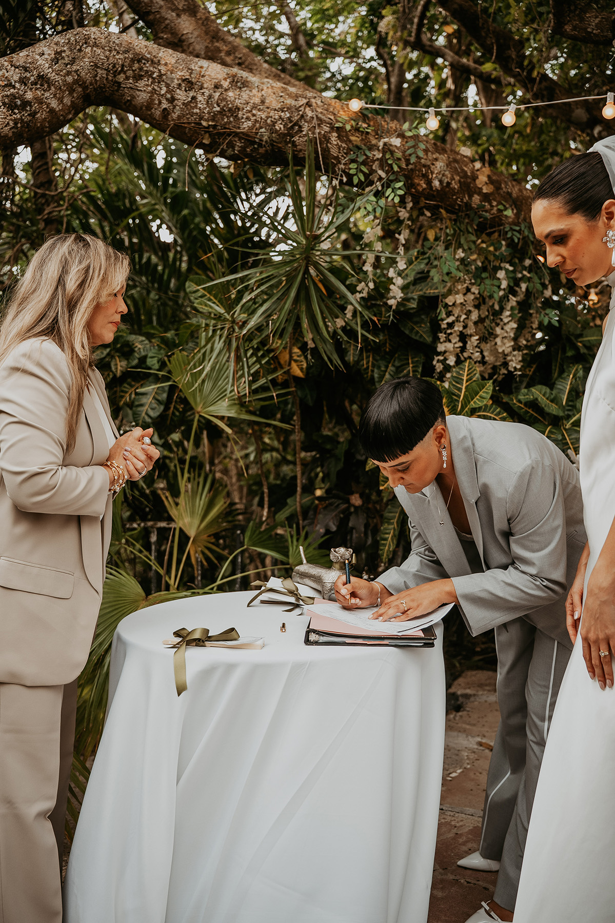 Lesbian newlywed couple signing official wedding documents