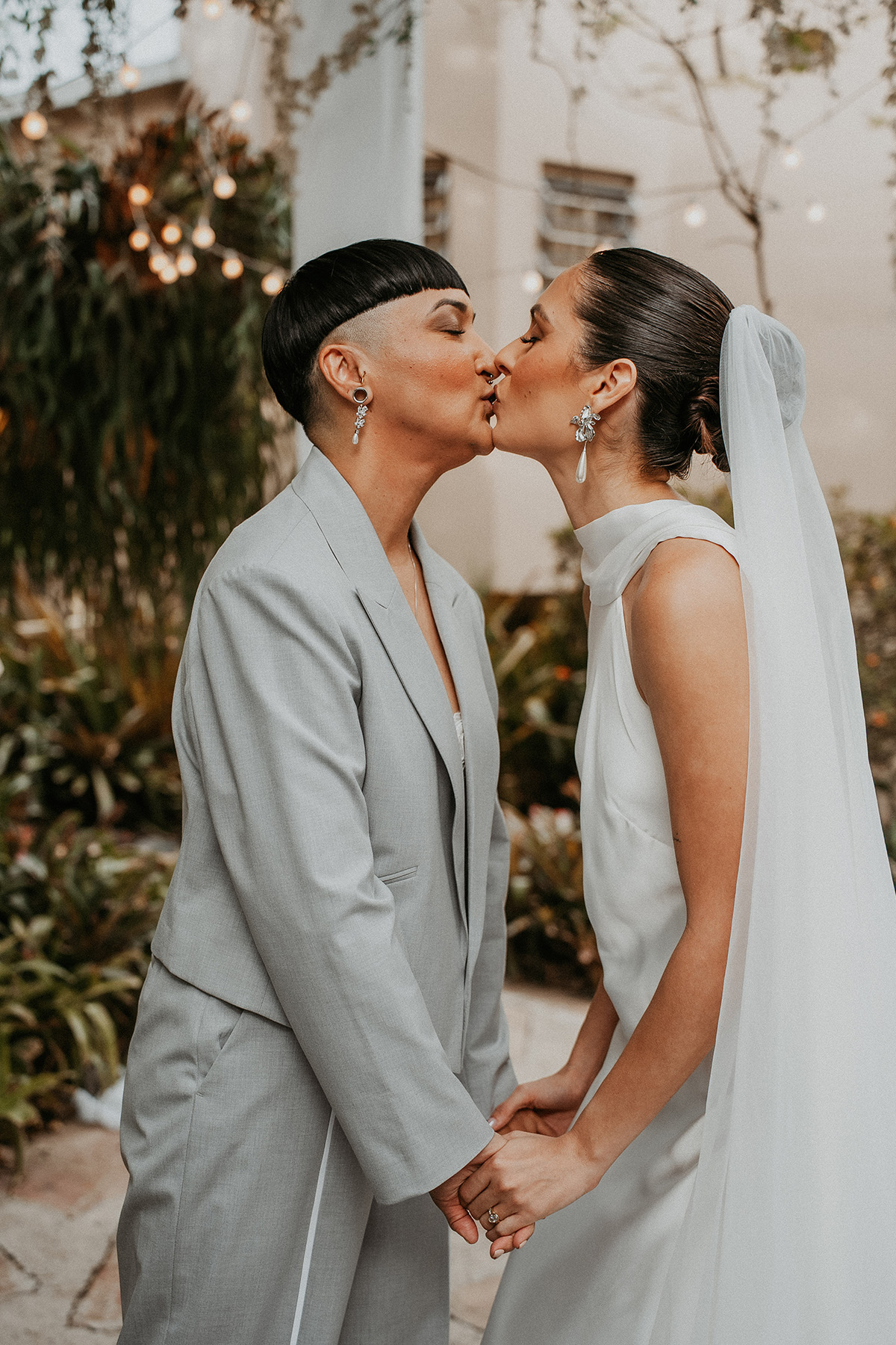 Two brides sharing their first kiss during their wedding ceremony