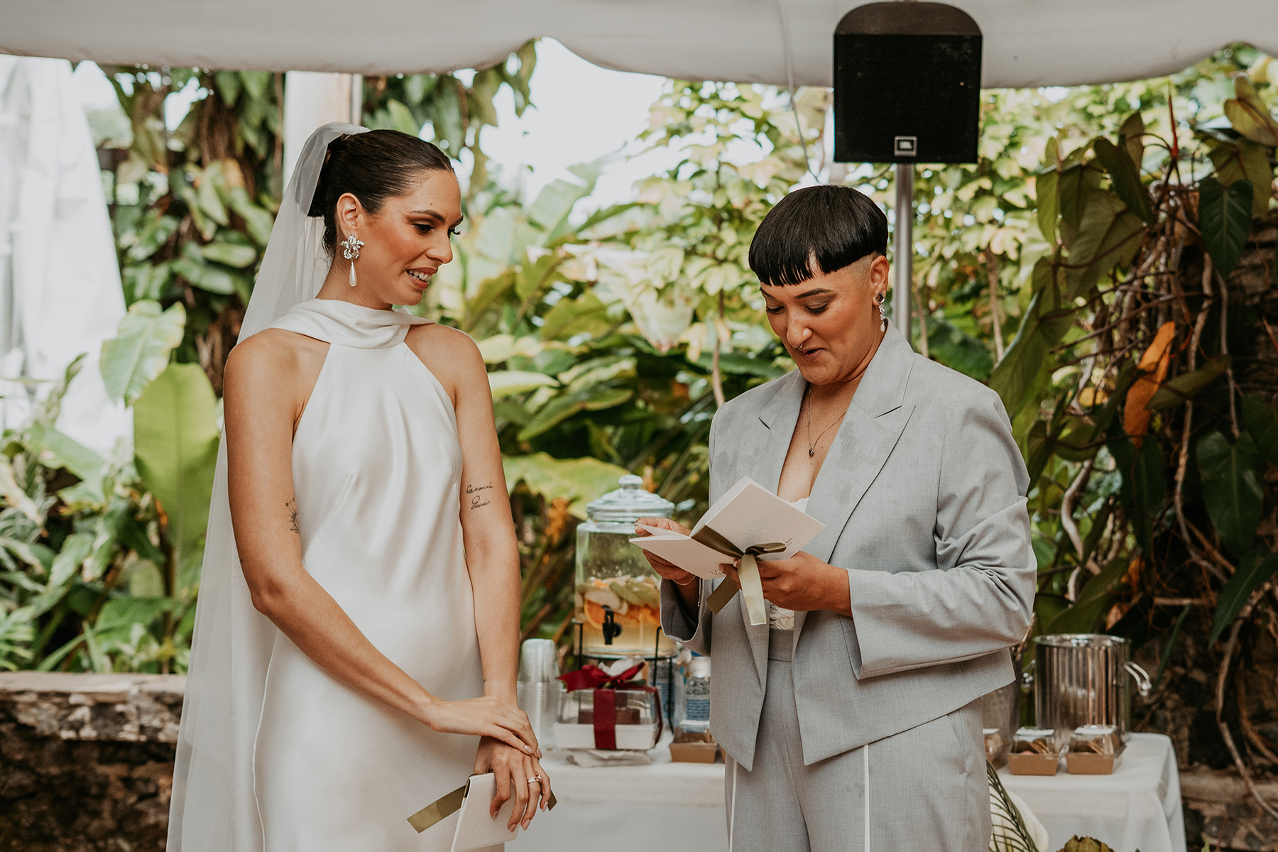 Newlywed couple surrounded by laughing wedding guests