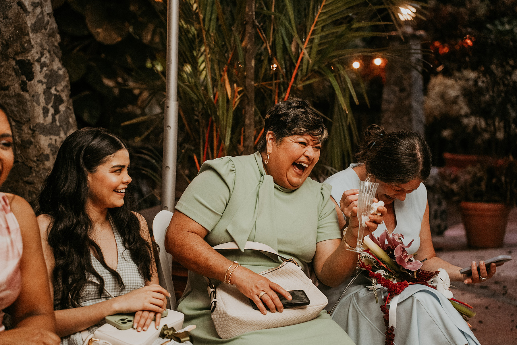 Wedding guests laughing together durFriends and family celebrating two brides after their Puerto Rico weddinging the reception