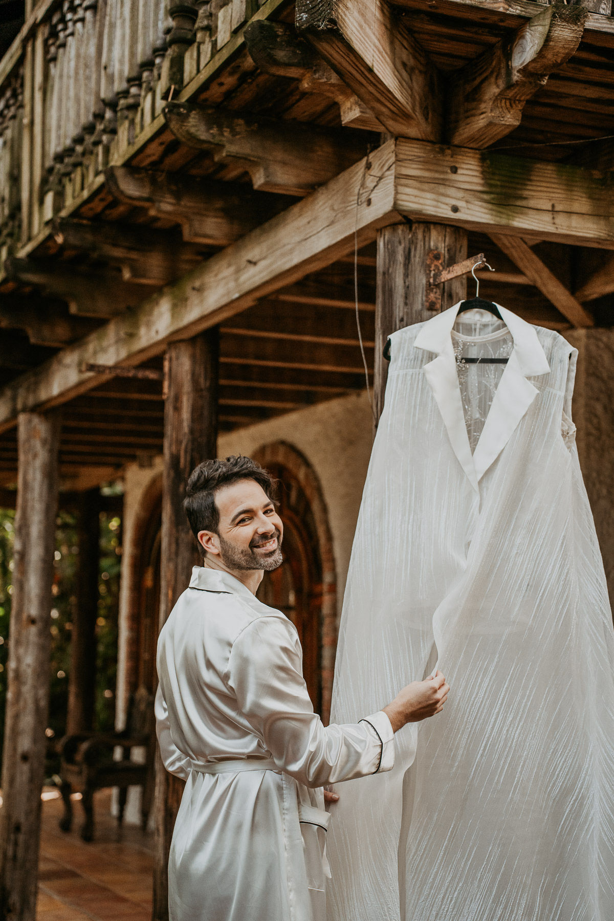 Groom looking at his wedding outfit.