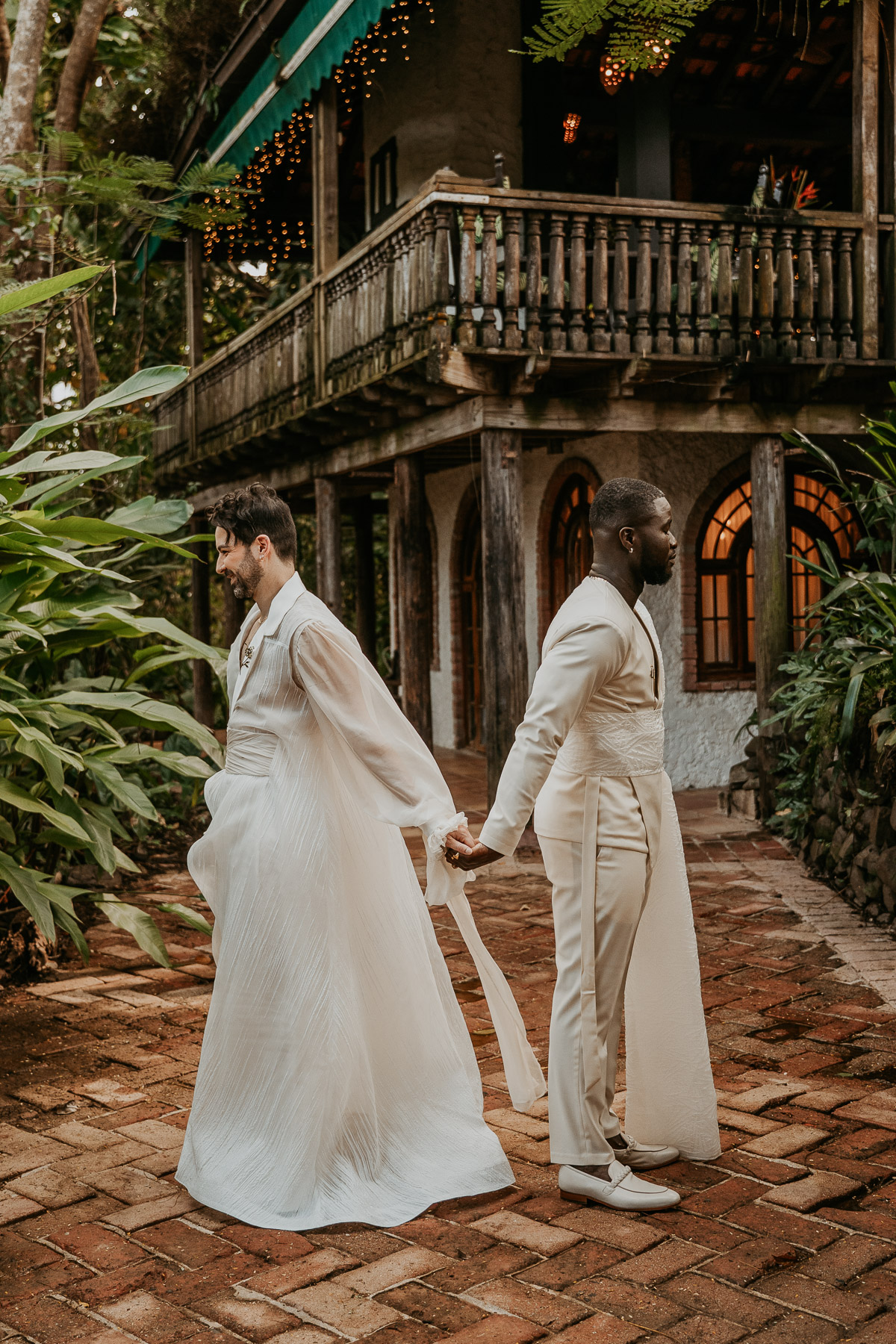 A joyful LGBTQ+ couple sharing an emotional first look surrounded by lush greenery at Hacienda Siesta Alegre.