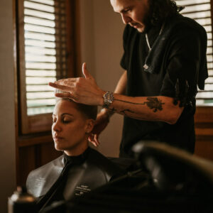 Lesbian bride getting haircut by barber during getting ready before wedding ceremony
