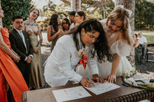 Lesbian couple signing inclusive forms during wedding ceremony