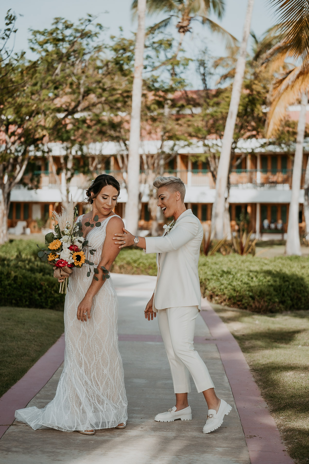 First look moment between two brides at Copamarina Beach Resort garden.