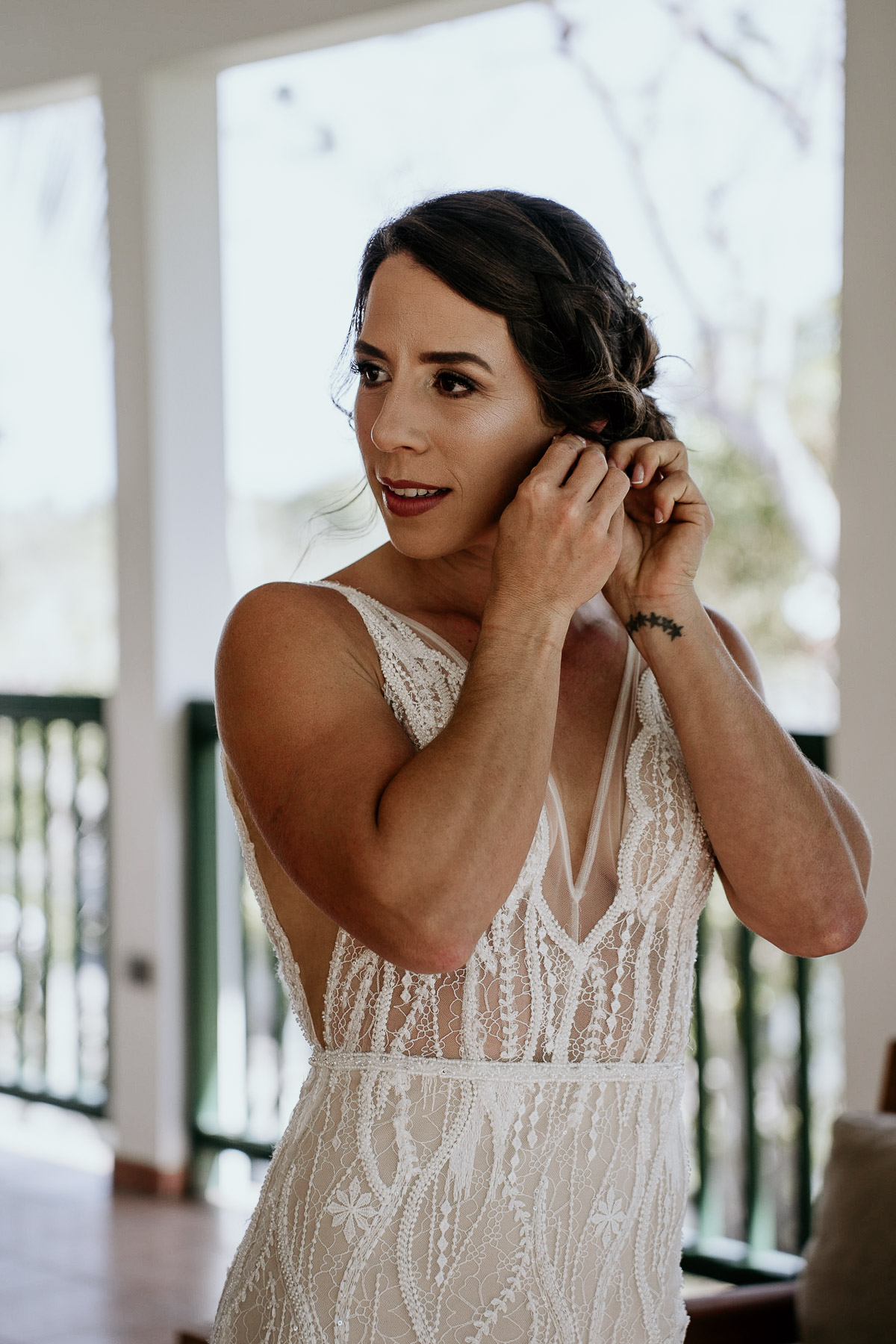 Bride putting on jewelry at Copamarina Beach Resort.