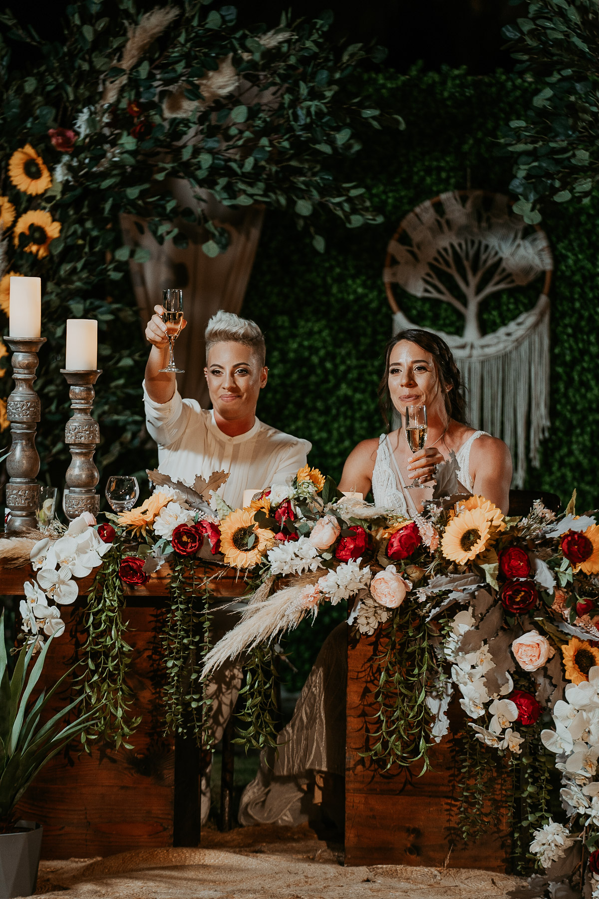 Brides raise glass during wedding toast.