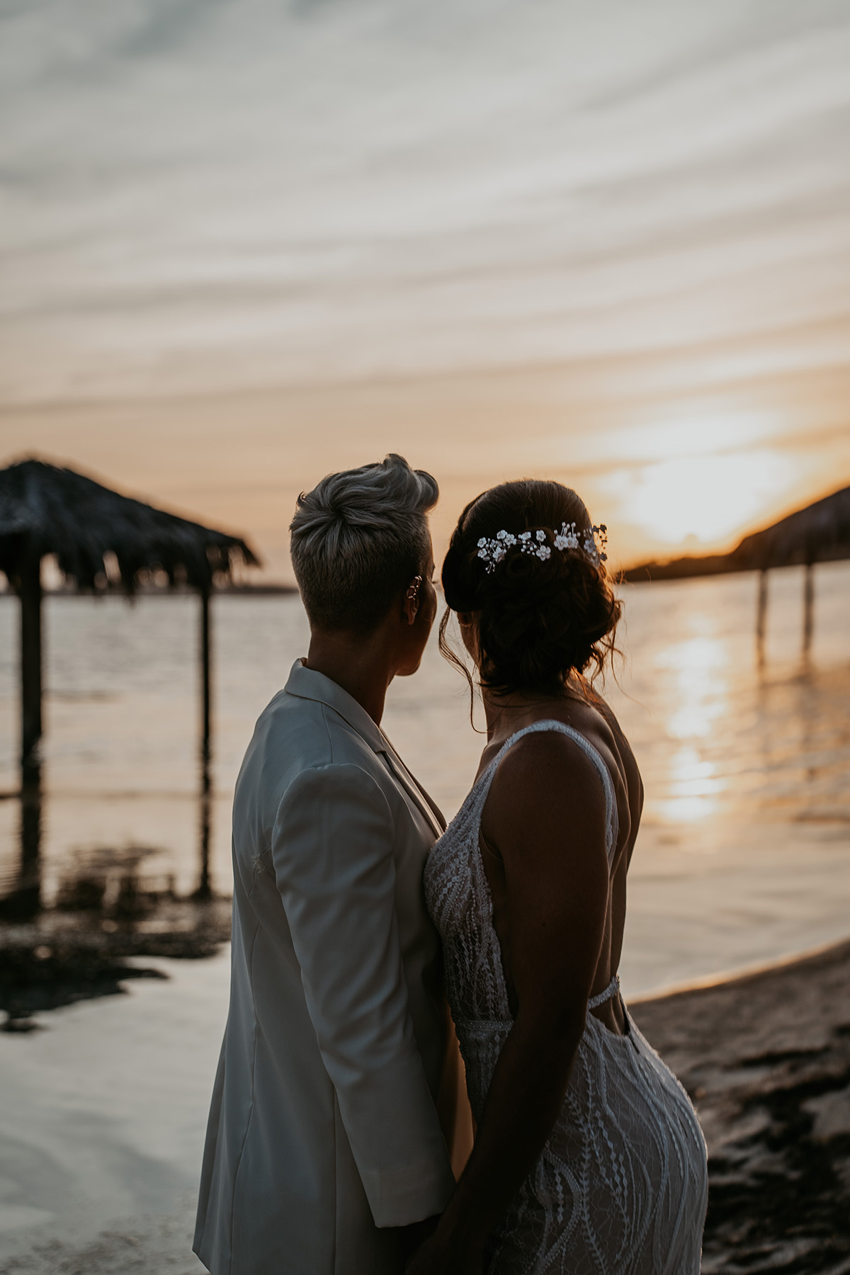 Two Brides Looking at sunset during their LGBTQ+ Wedding at Copamarina Beach Resort.