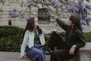 Nilka Gissell photographer with partner admiring flowers during lesbian couple session