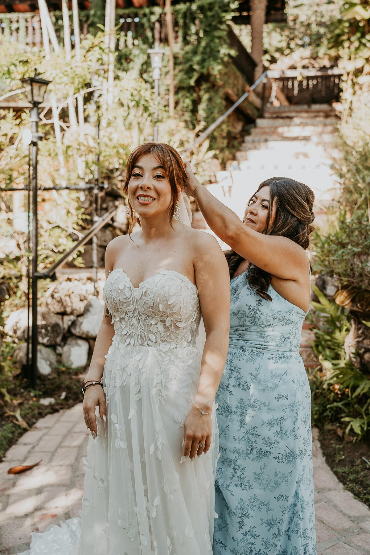 Bride getting her veil on by her mother.