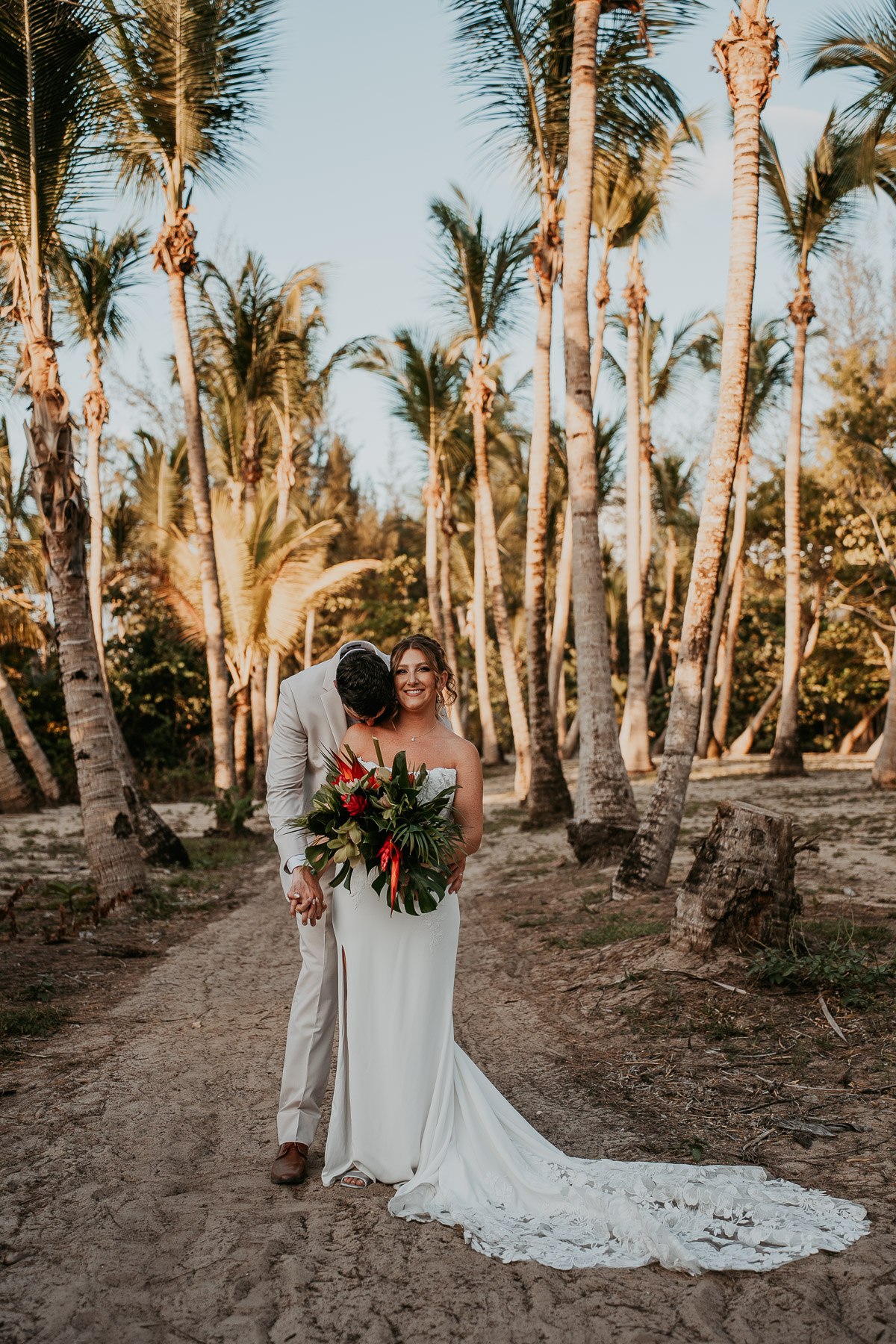 Groom kissing bride's shoulder after wedding ceremony