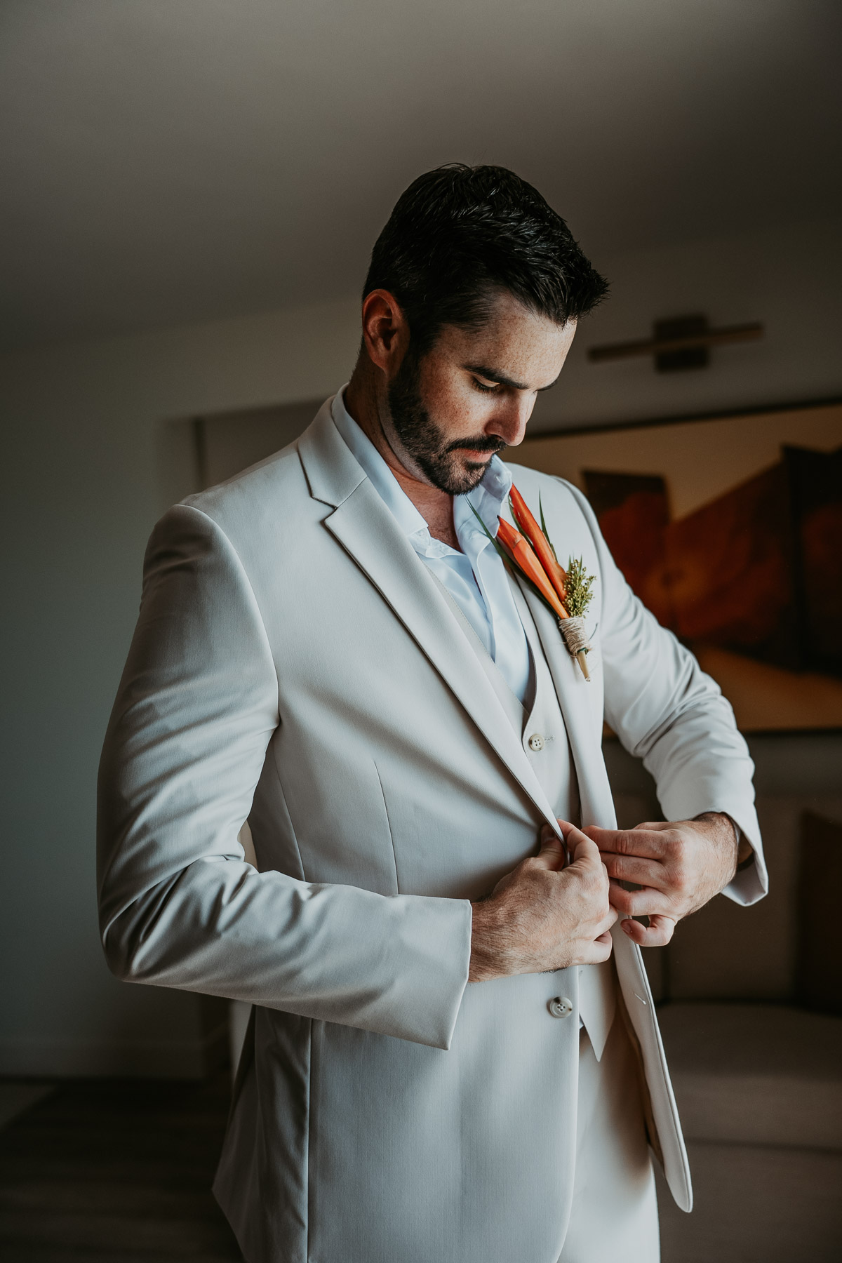 Groom adjusting wedding suit