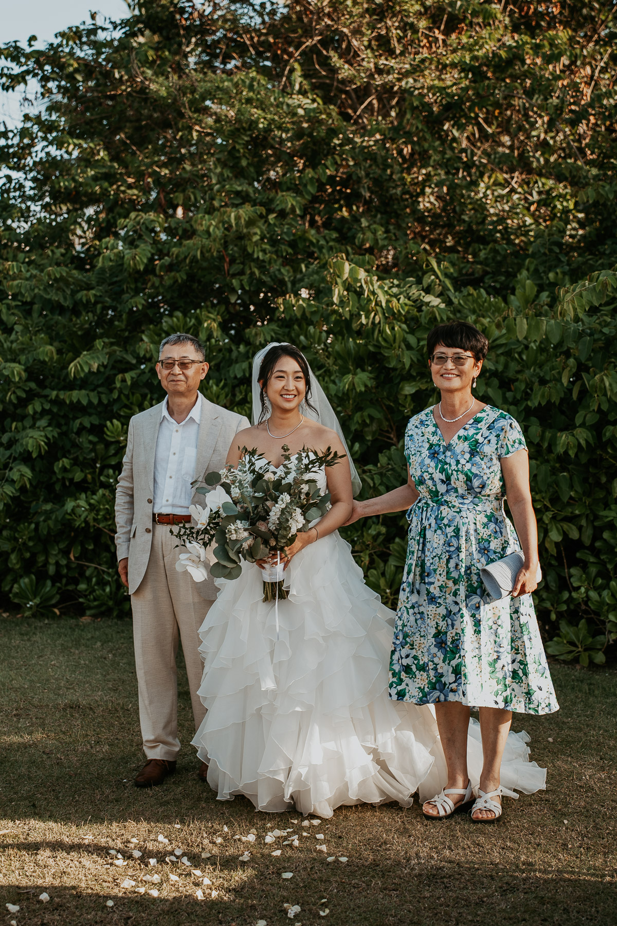 A smiling bride walking down the outdoor aisle toward the ocean altar.
