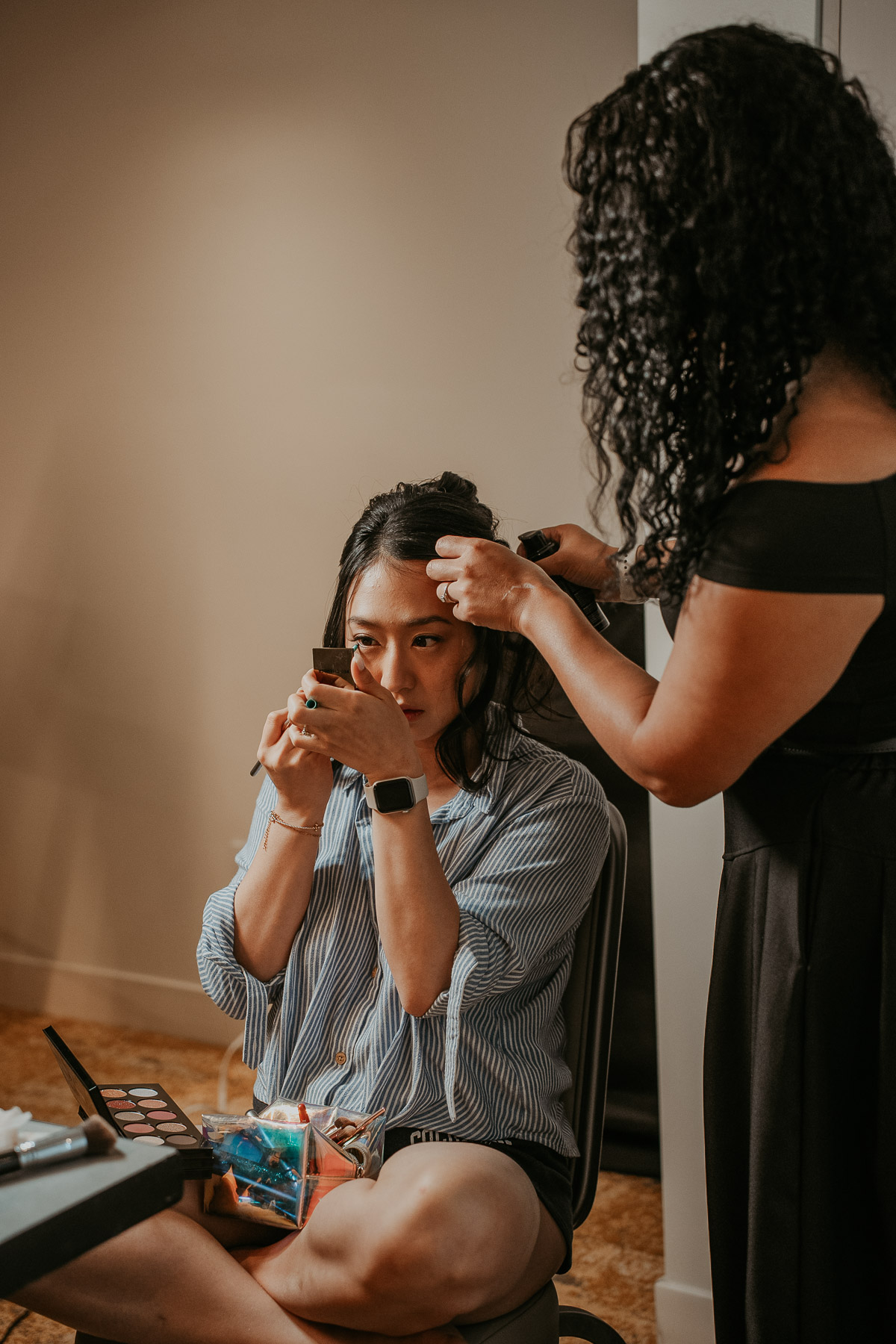 Close up of a bride getting her makeup and hair finished under soft, diffused natural light.