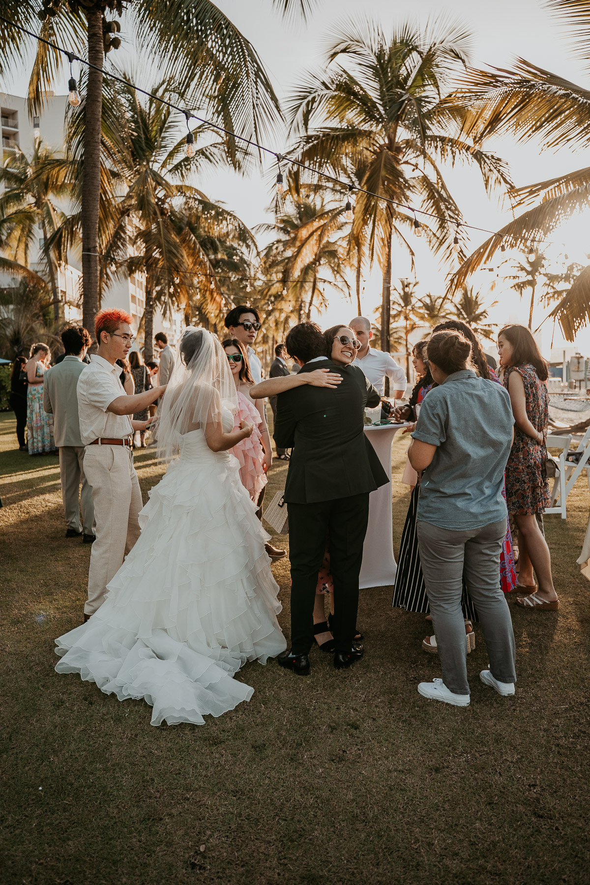 Wedding guests mingling outdoors during cocktail hour at a Marriott beach wedding venue.