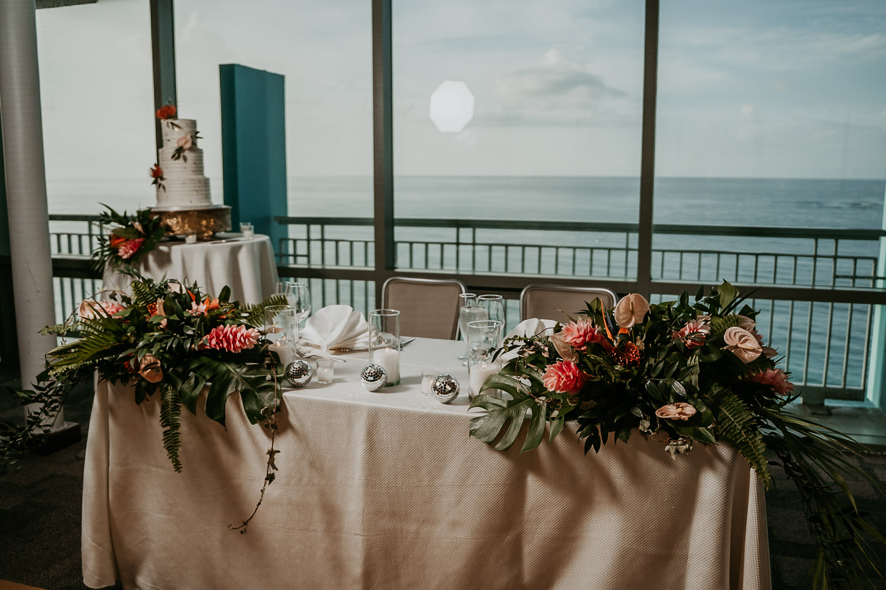 Reception tables with colorful centerpieces in Salón Mirador overlooking the ocean.
