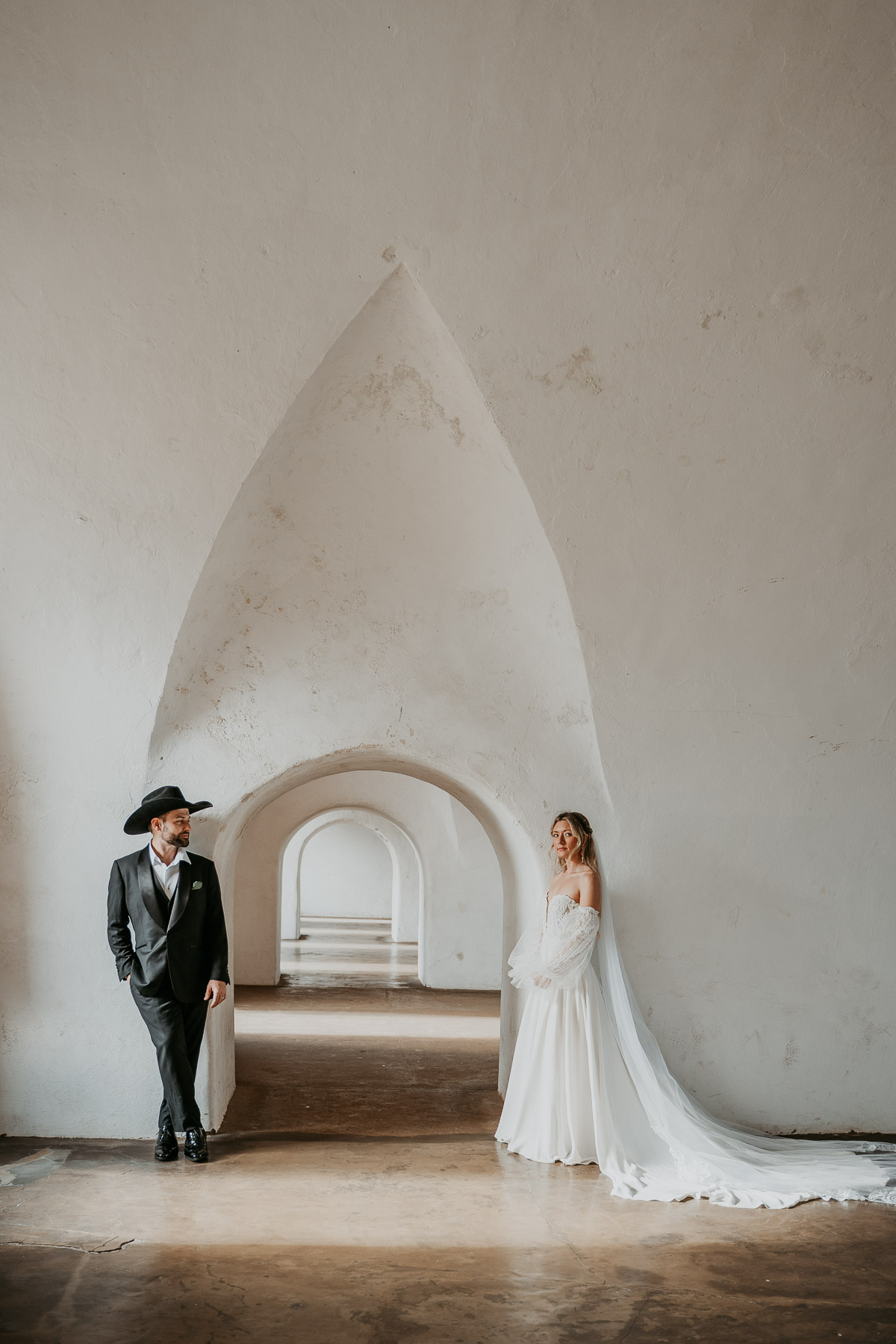 Editorial bride and groom photo under architectural white arch in Old San Juan.