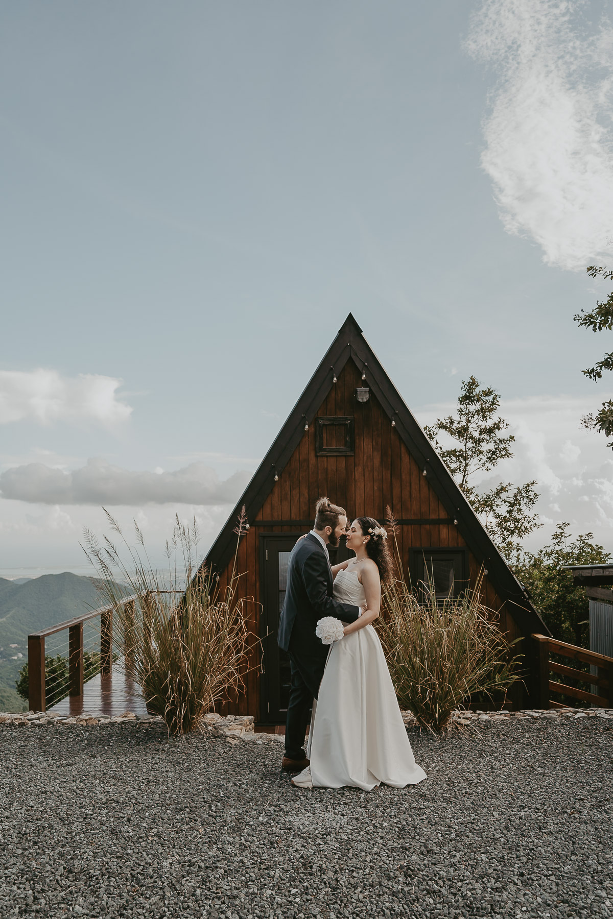 Couple standing in front of an A-frame house with mountain views in Cayey, Puerto Rico