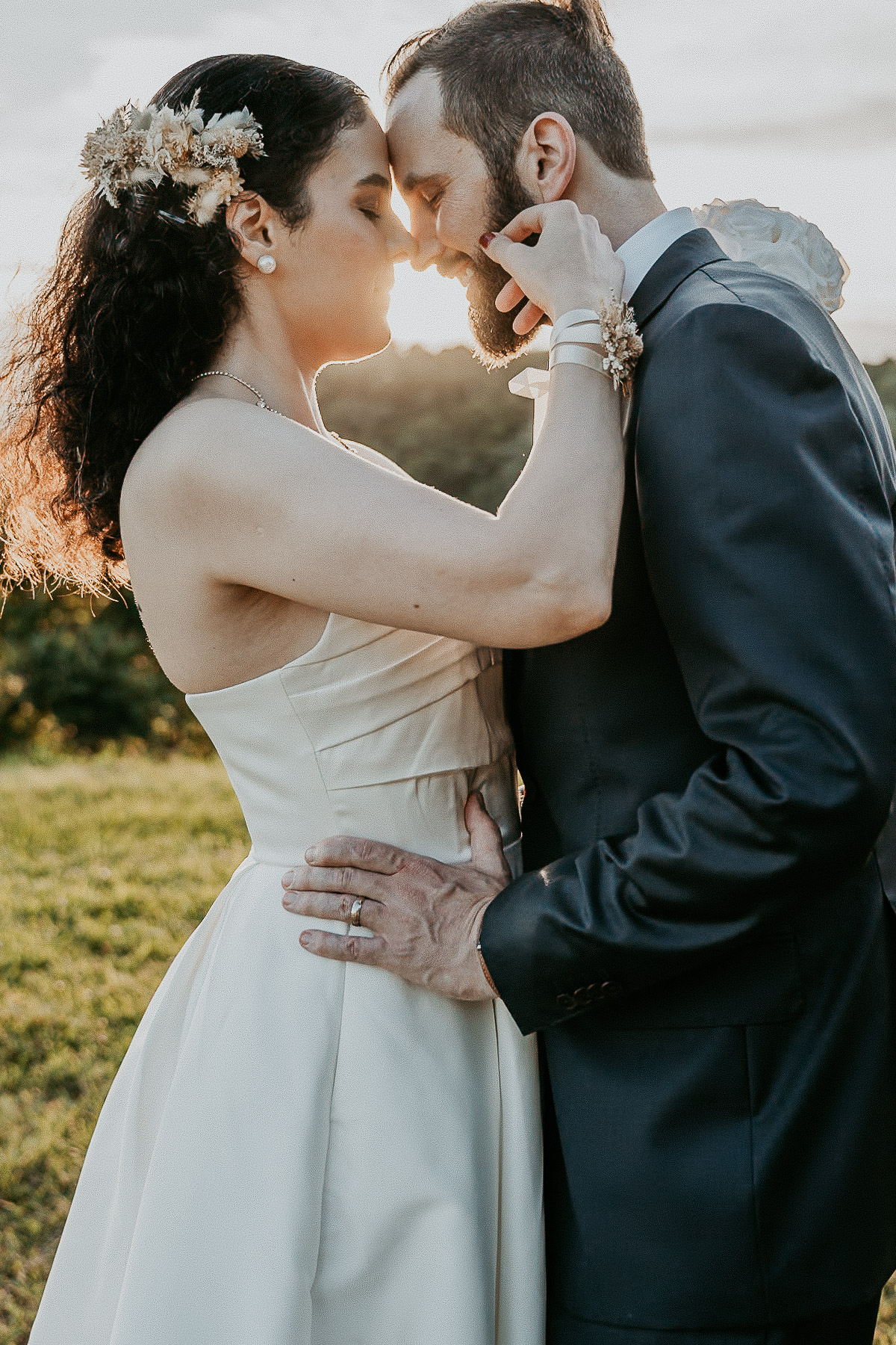 Bride and groom silhouetted against the sunset over the mountains in Cayey