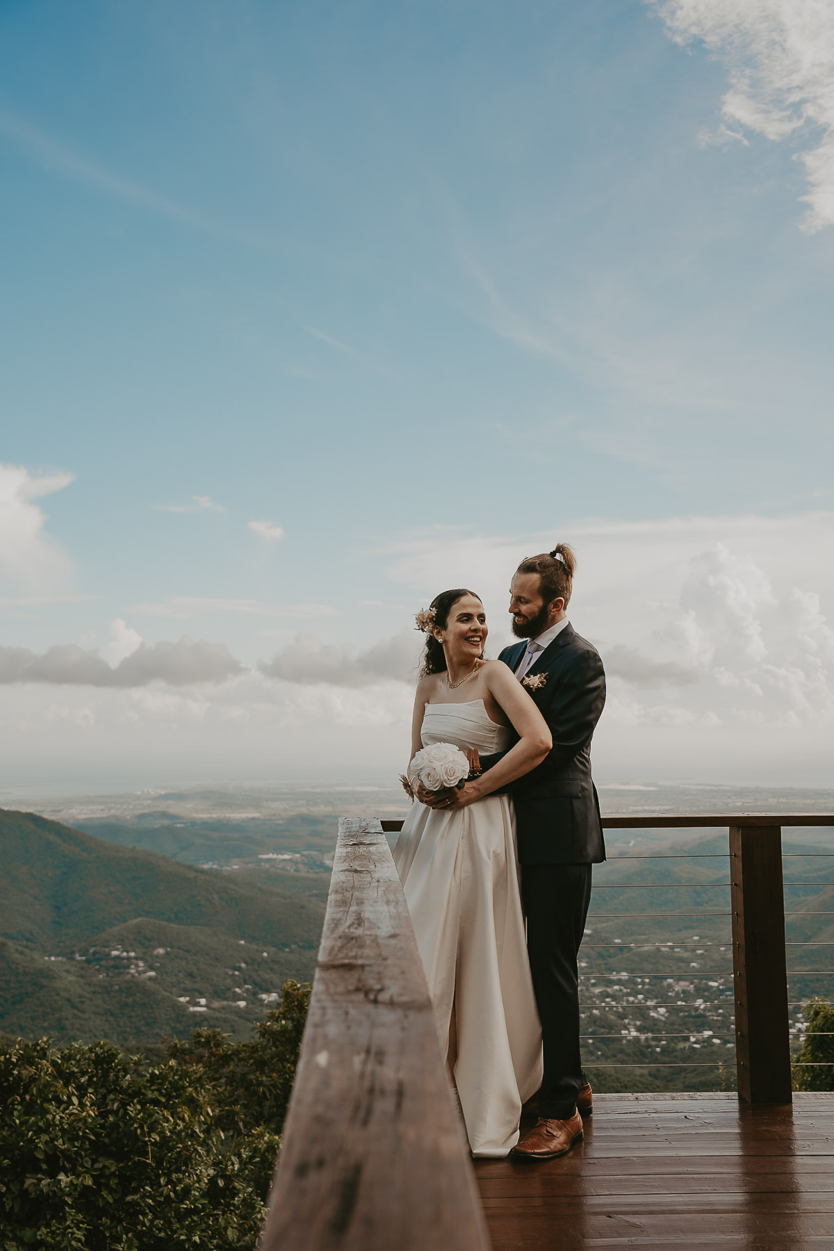 Bride and groom embracing with the panoramic mountain view from the Cayey campground.