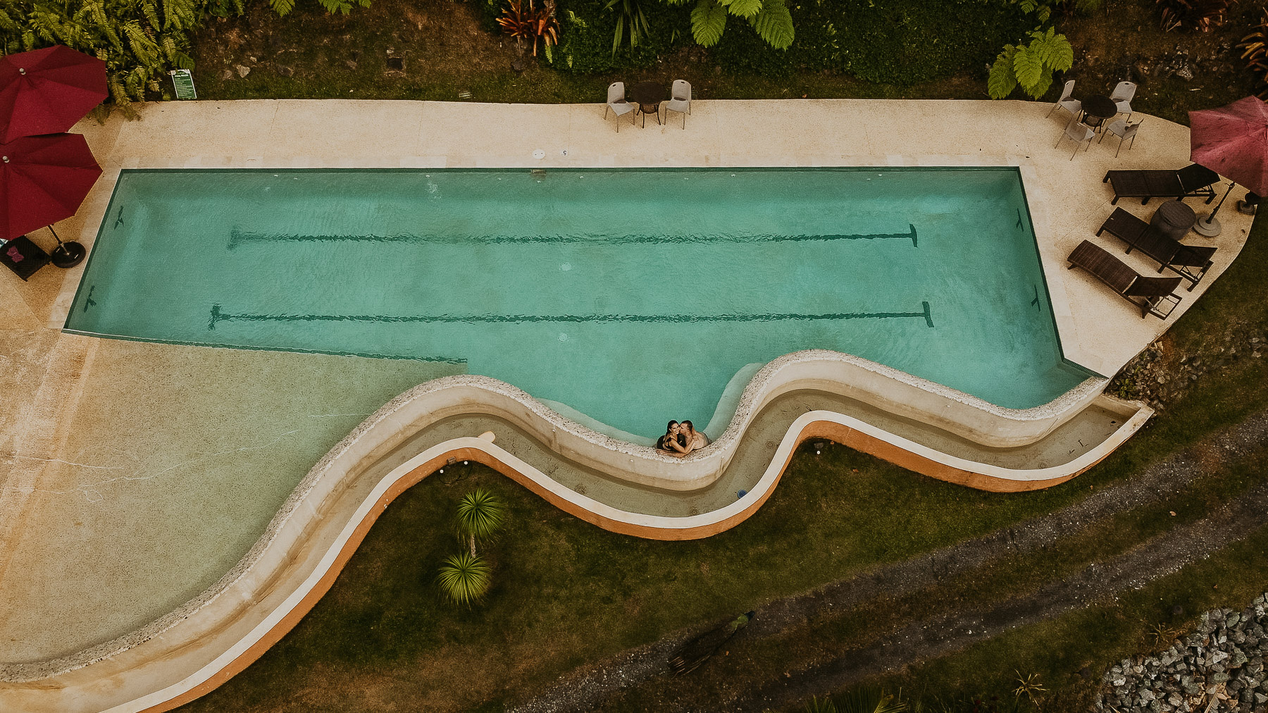 Aerial view of a couple enjoying the pool during their couples session at Mont Carpe Diem in Puerto Rico.